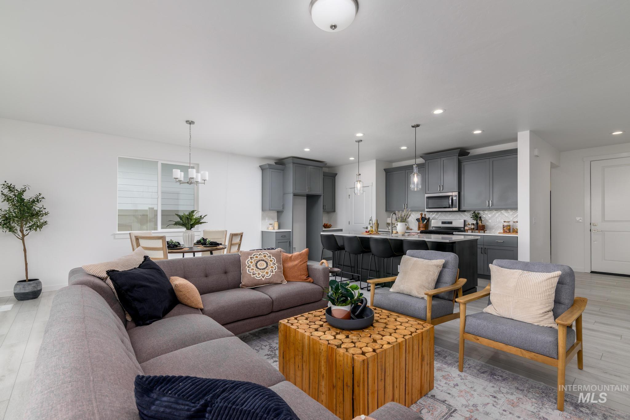 Living area featuring light wood-style floors, a chandelier, and recessed lighting