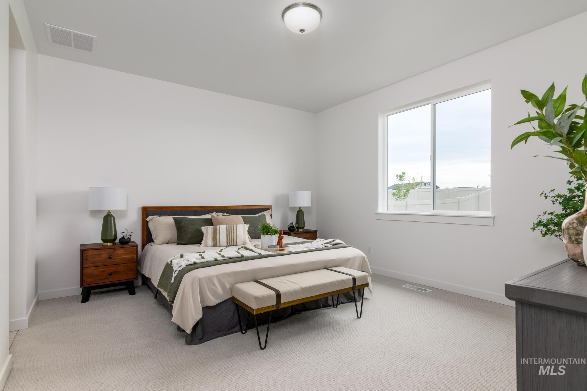 Bedroom featuring light colored carpet and baseboards