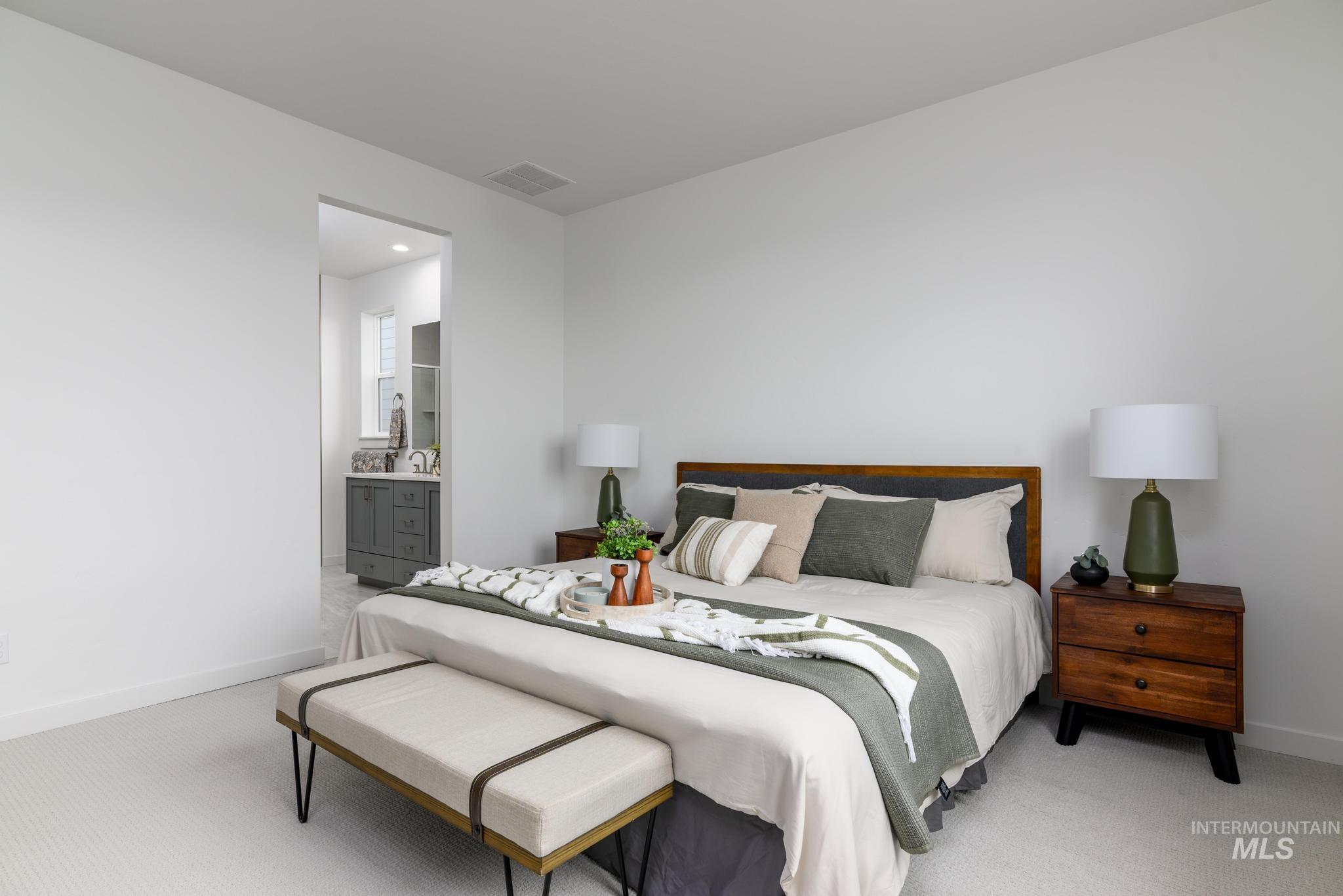 Bedroom featuring light carpet and connected bathroom