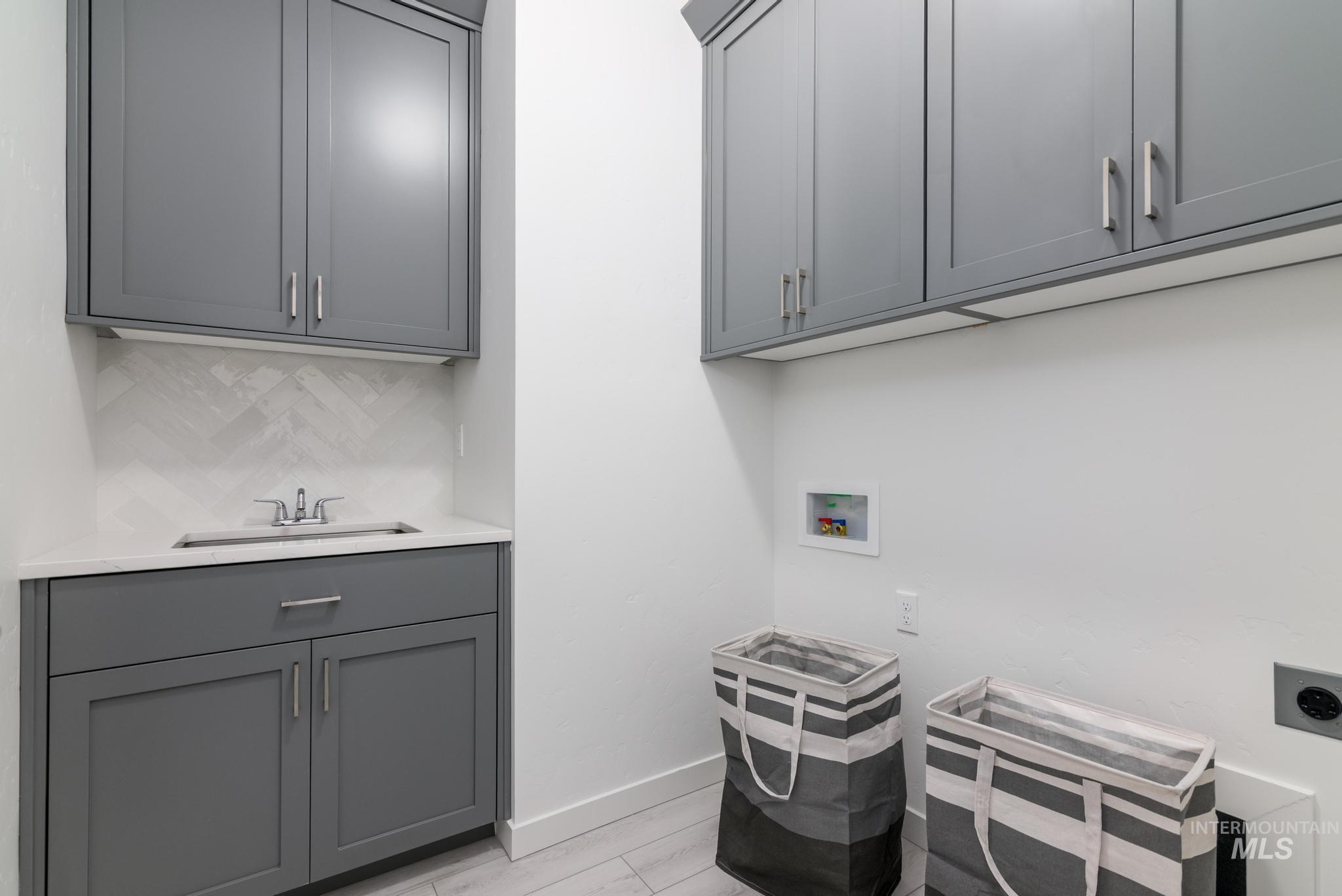 Laundry area with washer hookup and cabinet space