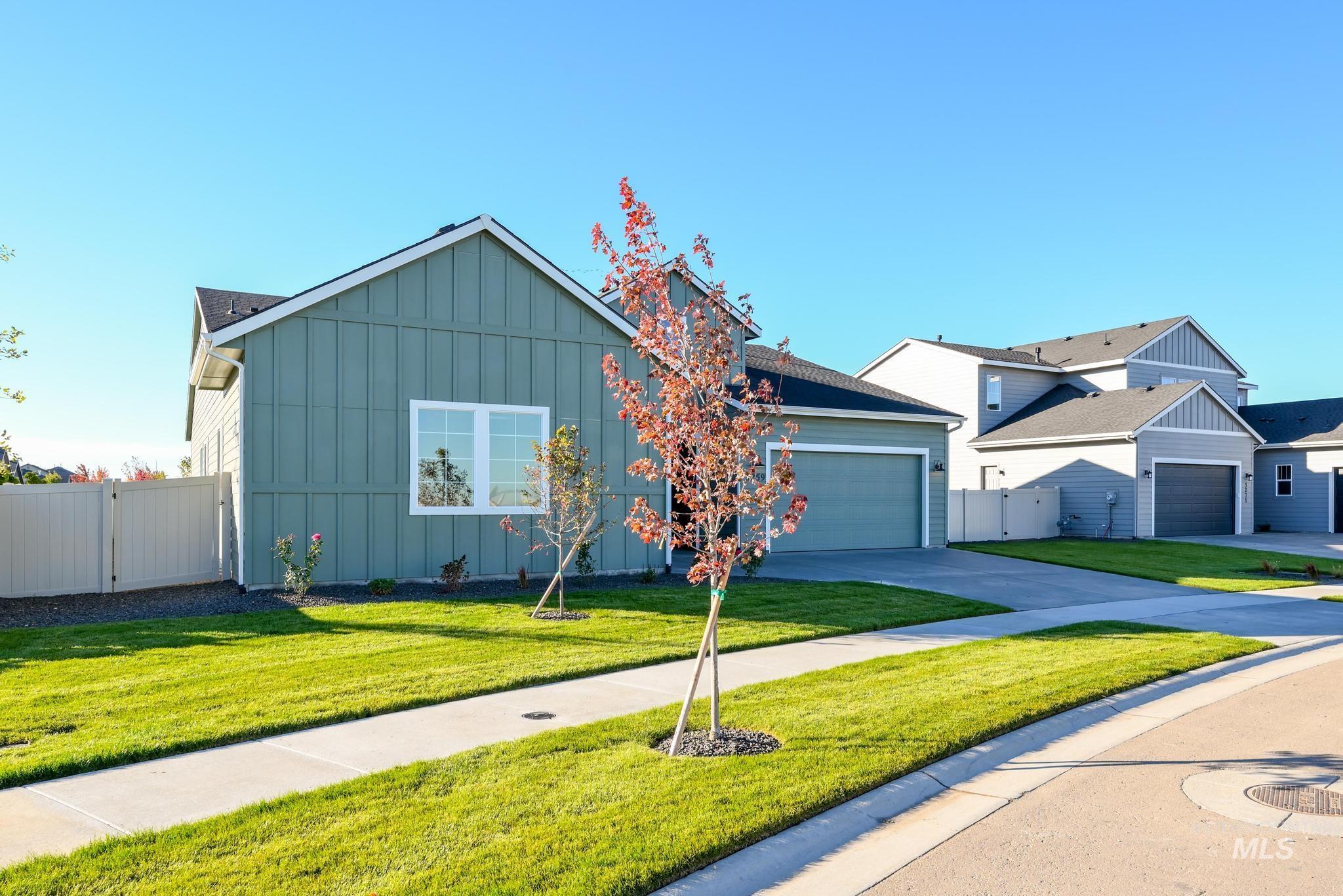 View of front of property with board and batten siding, concrete driveway, and an attached garage