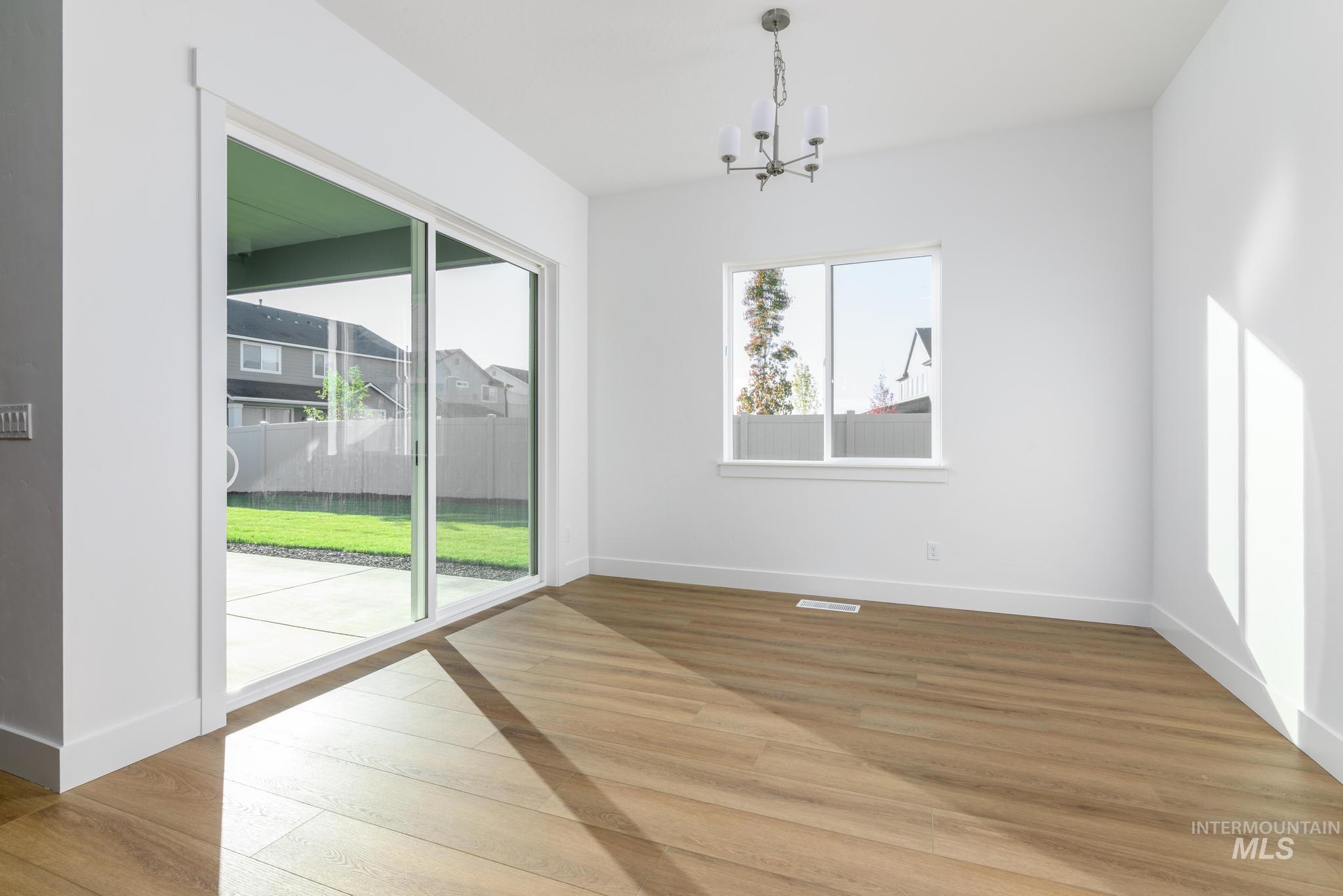 Unfurnished dining area with a chandelier and light wood finished floors