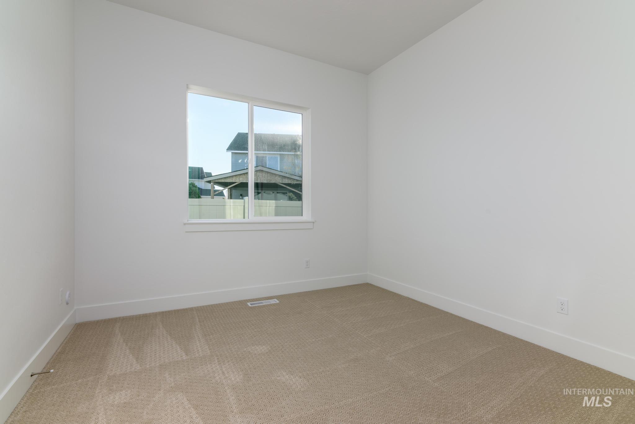 Carpeted empty room with baseboards
