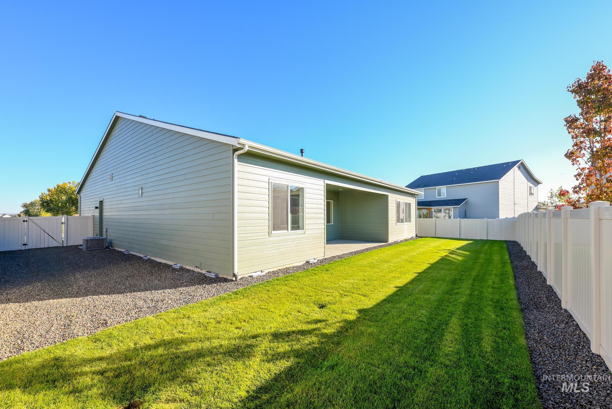 Back of property with a patio, a fenced backyard, and a gate