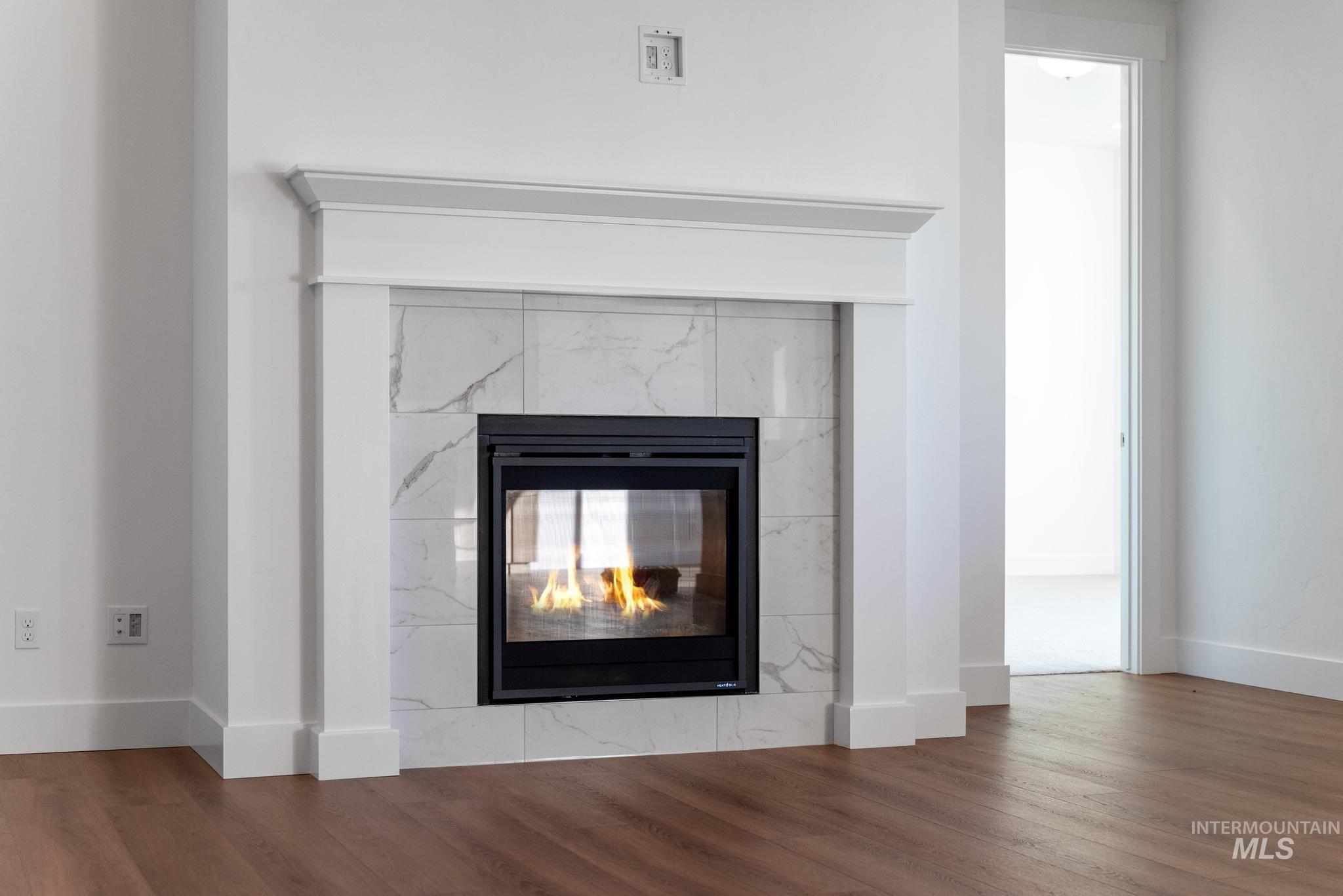Detailed view of wood finished floors and a fireplace