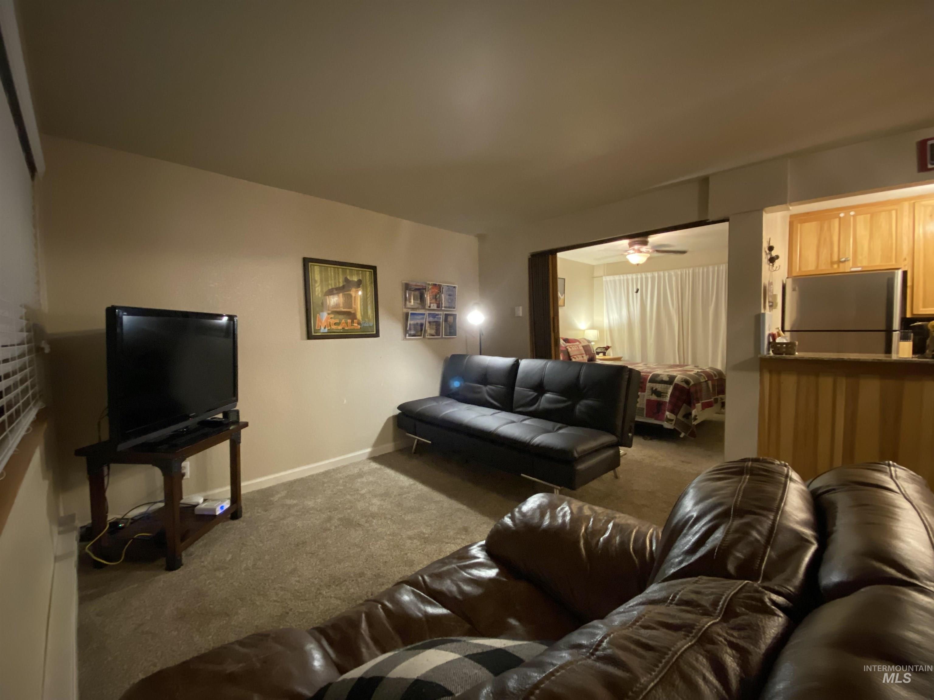 Living room with carpet floors and ceiling fan