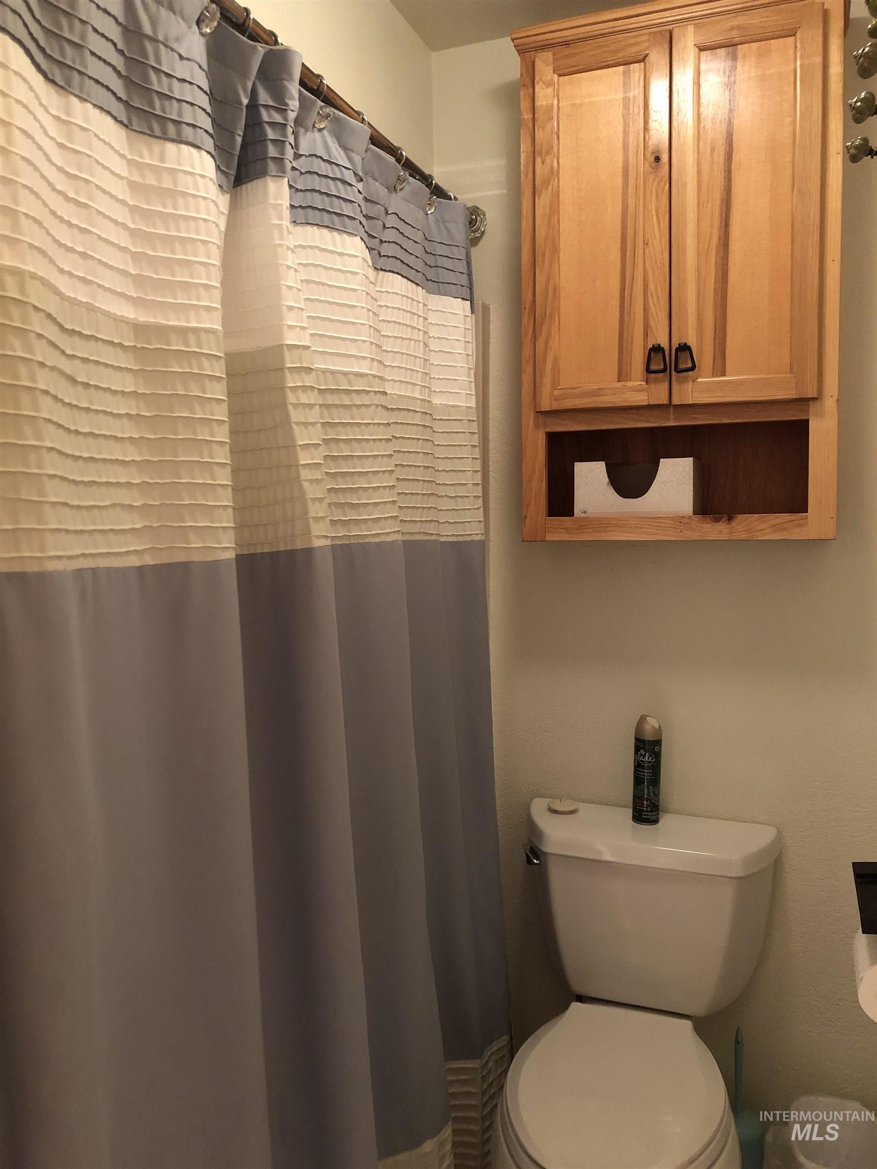 Full bathroom with a shower with shower curtain and toilet