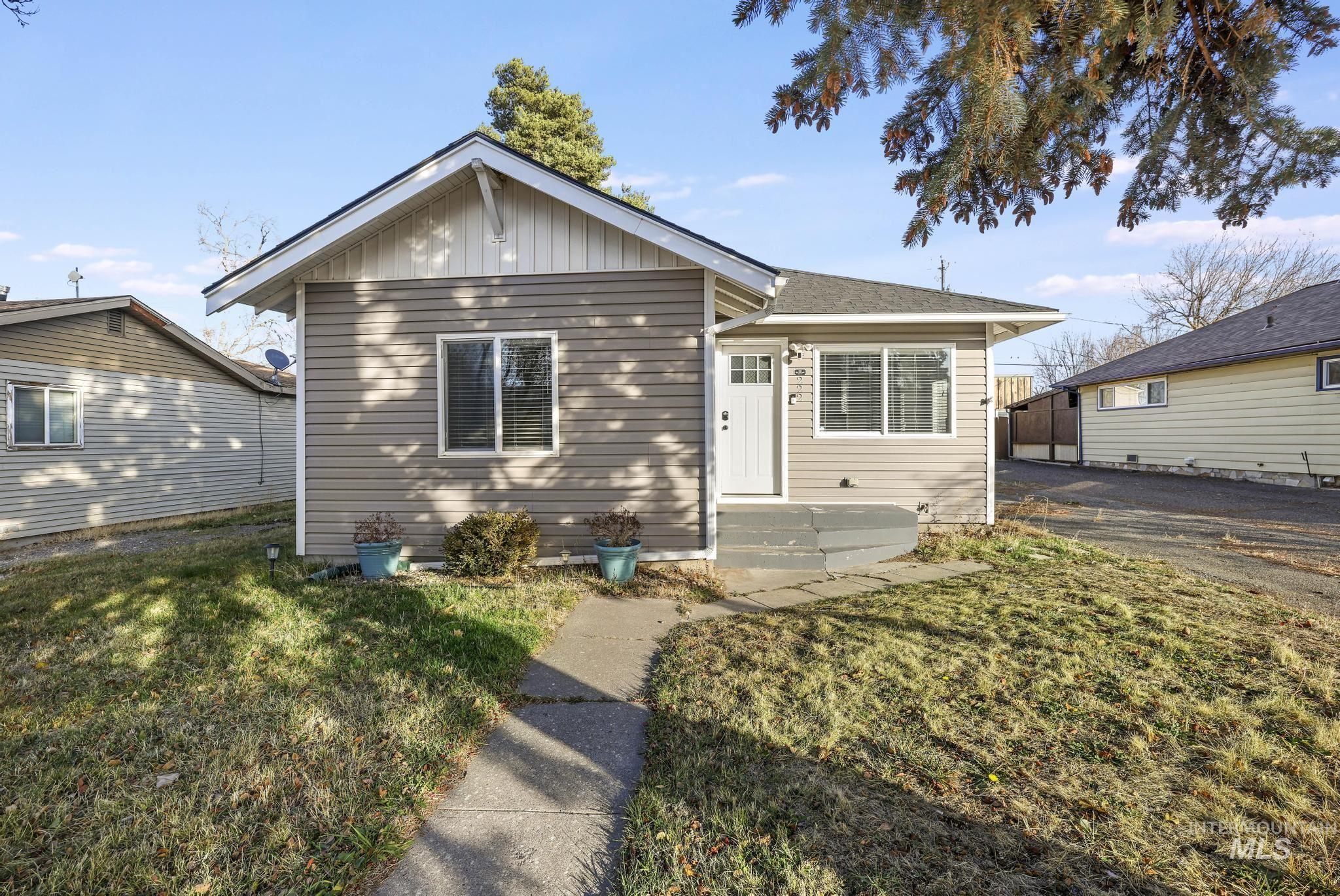Bungalow-style house featuring board and batten siding and a front yard