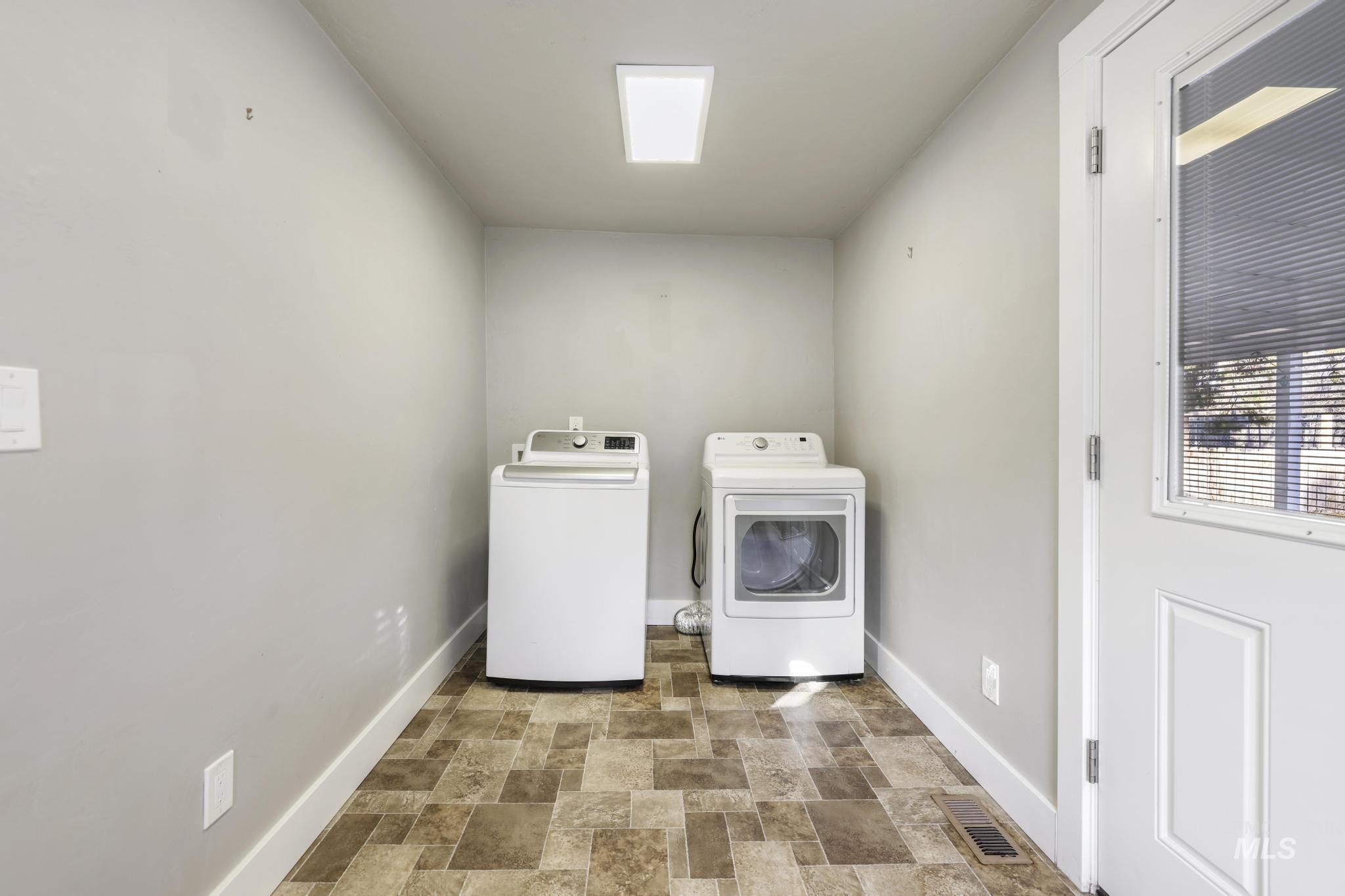 Washroom with stone finish flooring and independent washer and dryer