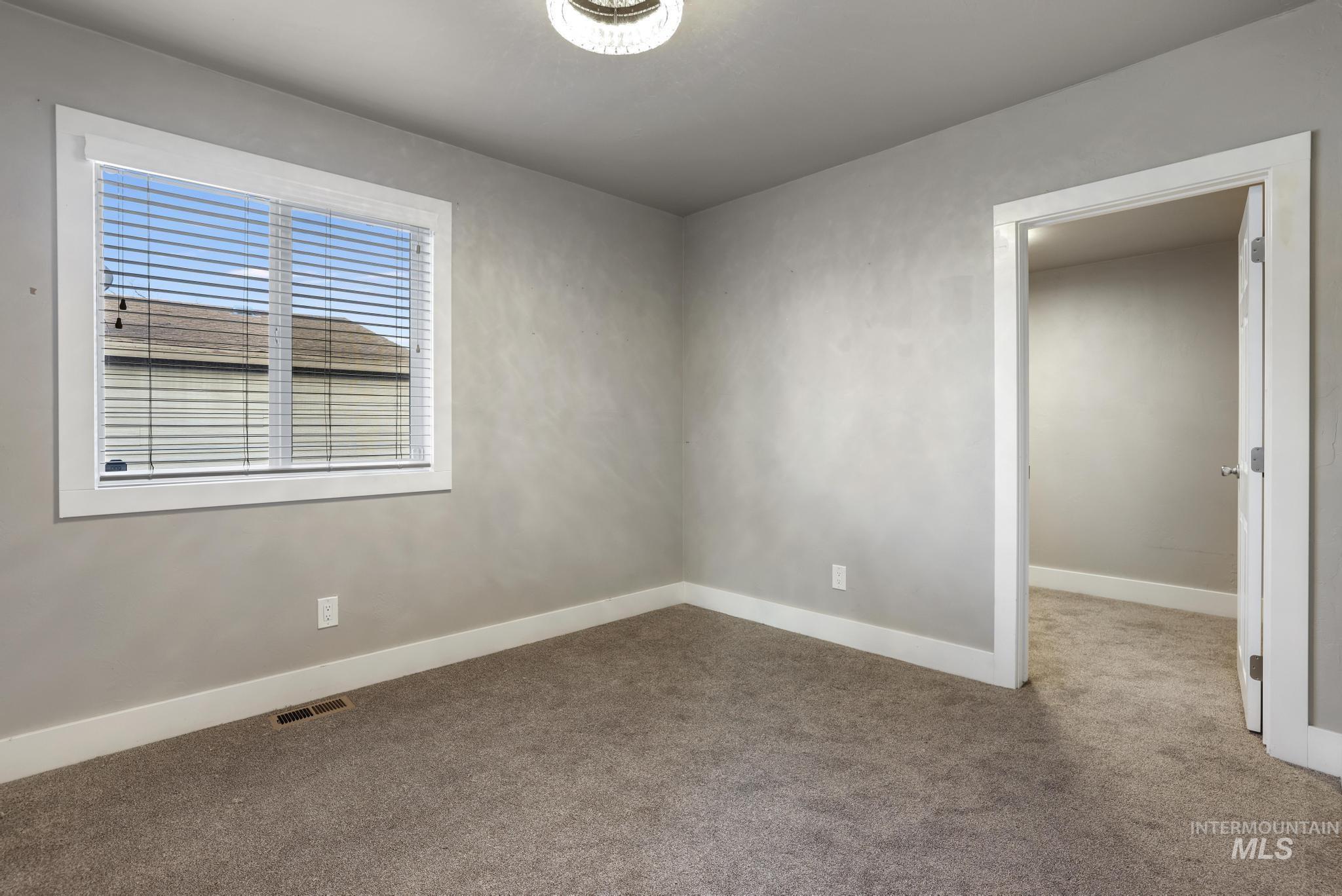 Carpeted spare room with baseboards