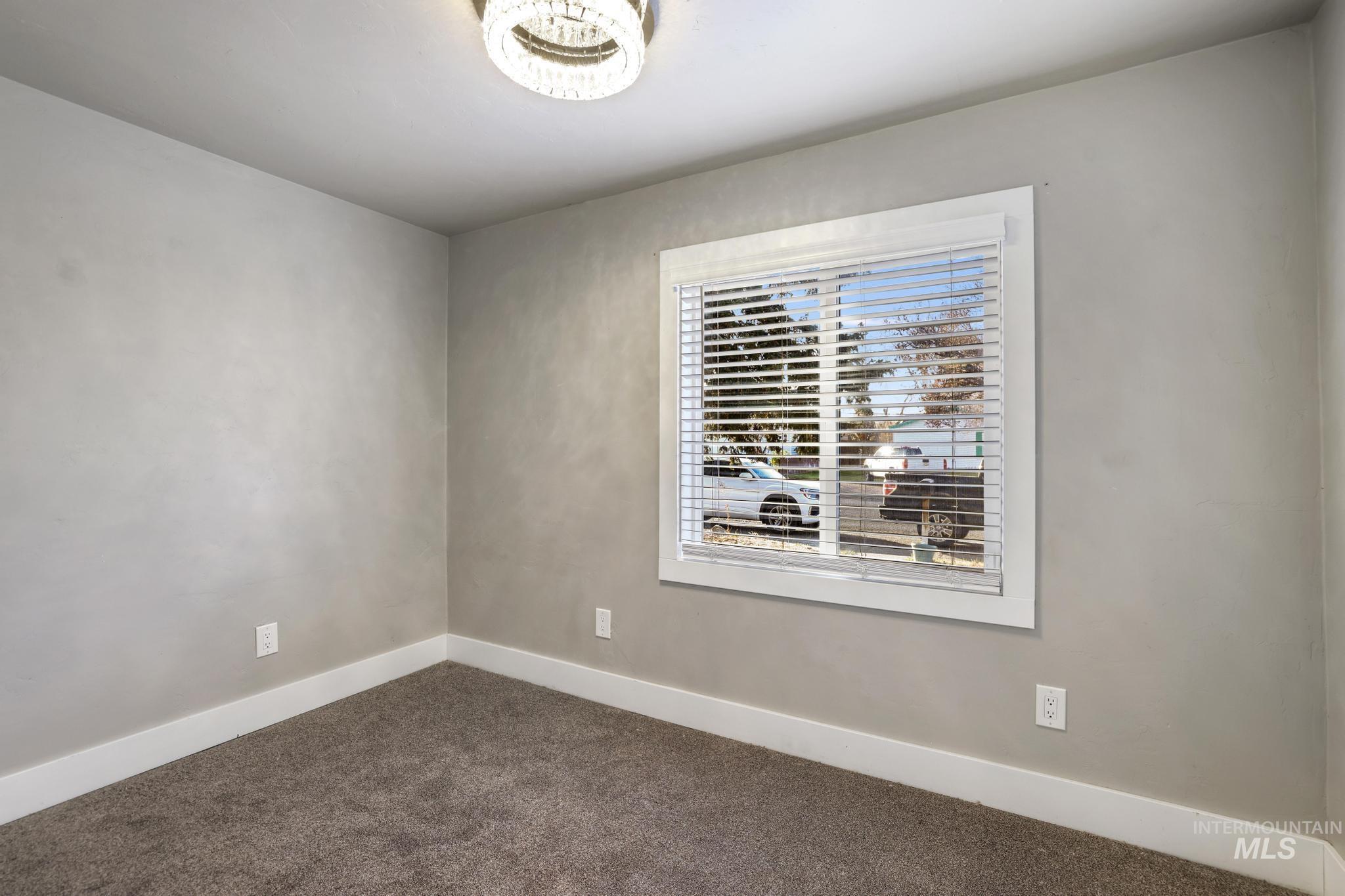 Spare room with baseboards and carpet
