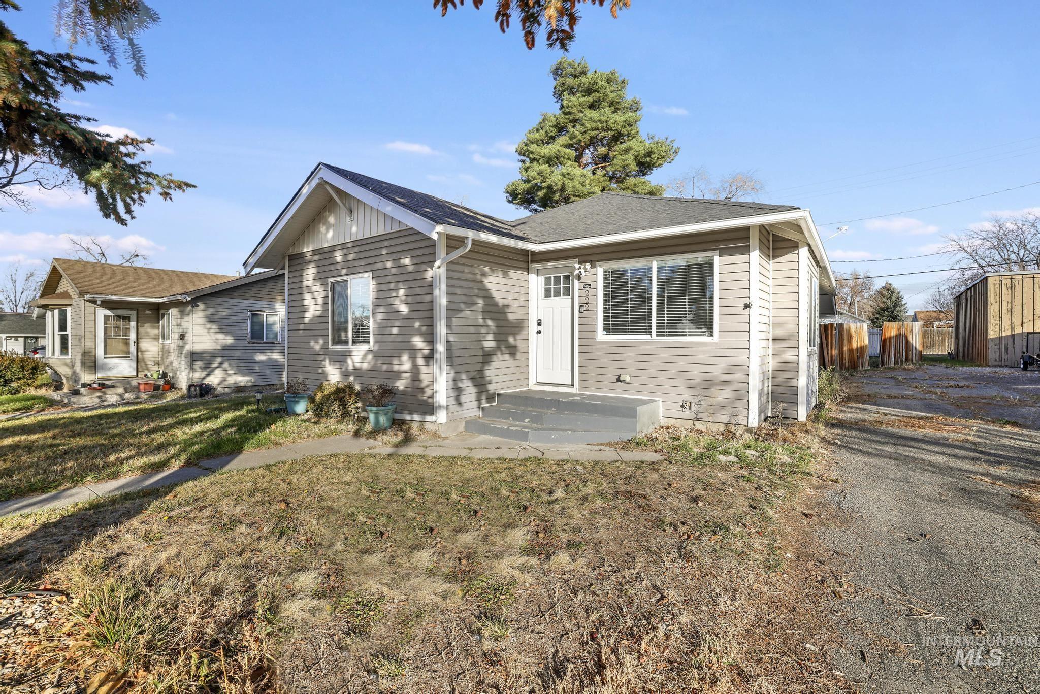 Bungalow-style home featuring a front yard, board and batten siding, and roof with shingles