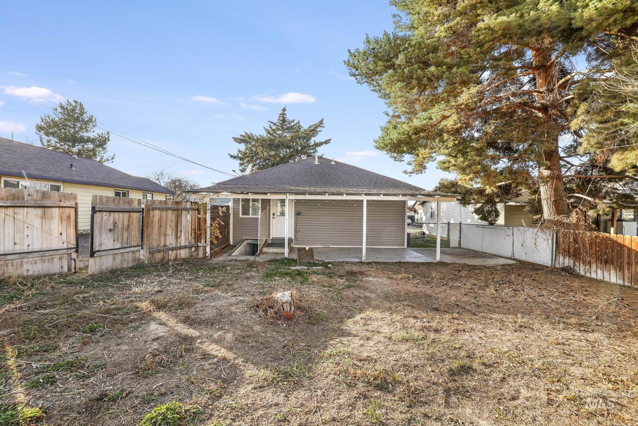 Rear view of house with a fenced backyard, a patio area, and roof with shingles