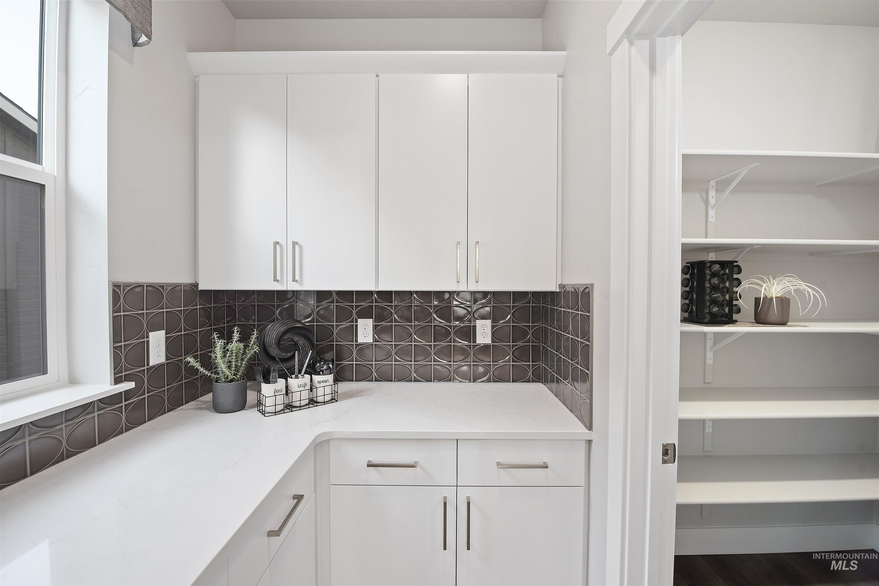 Kitchen featuring white cabinetry and decorative backsplash