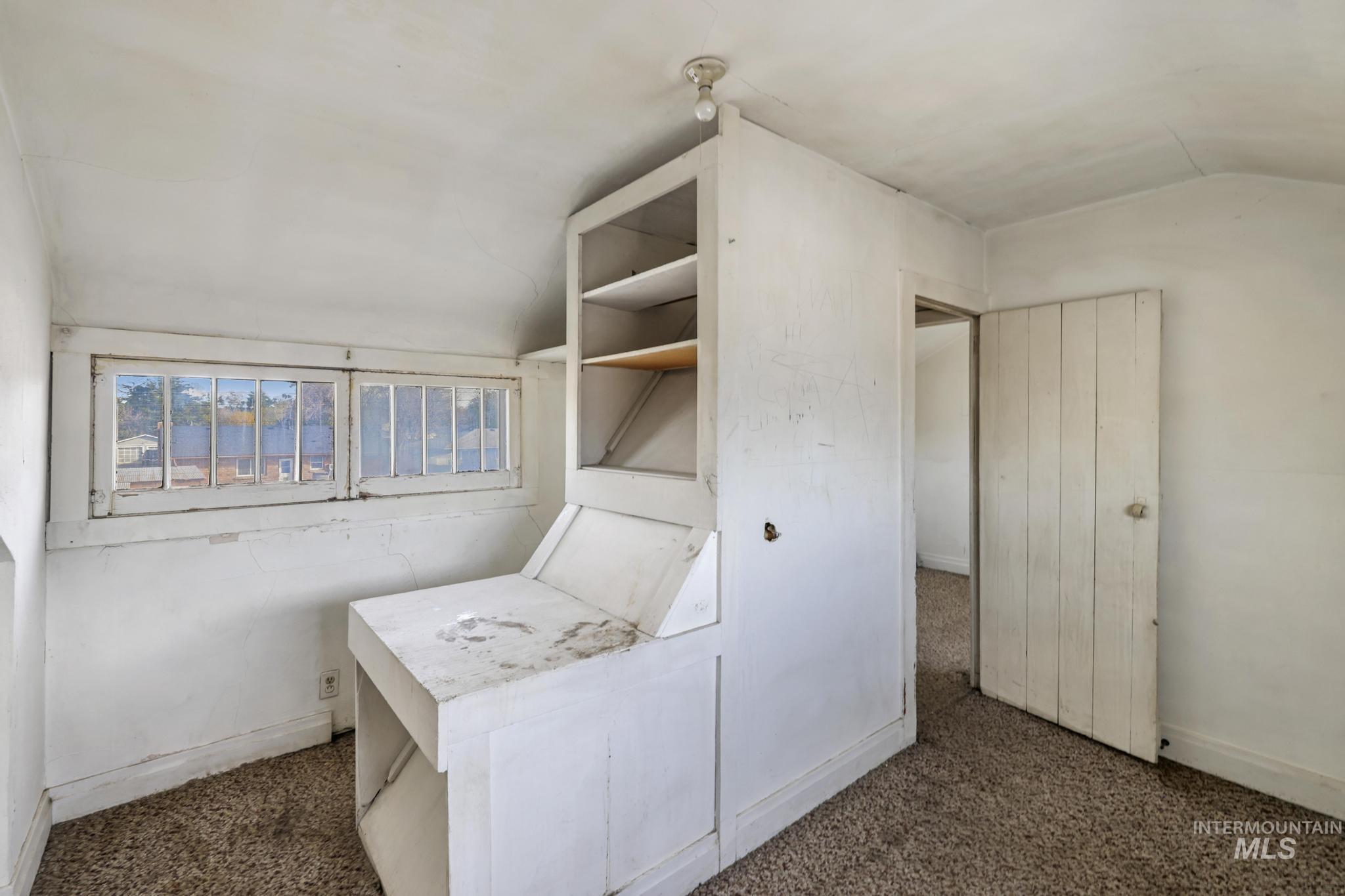 Washroom with vaulted ceiling and dark carpet