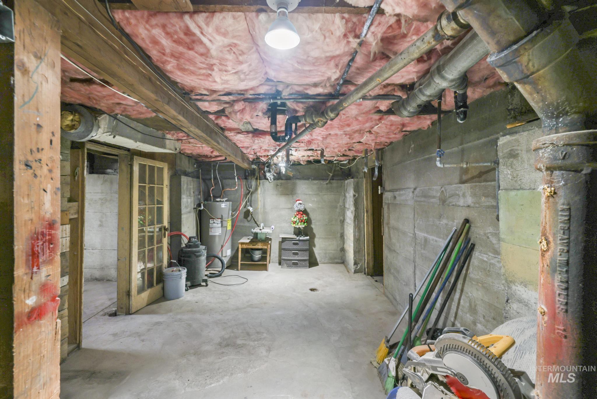 Unfinished below grade area featuring water heater