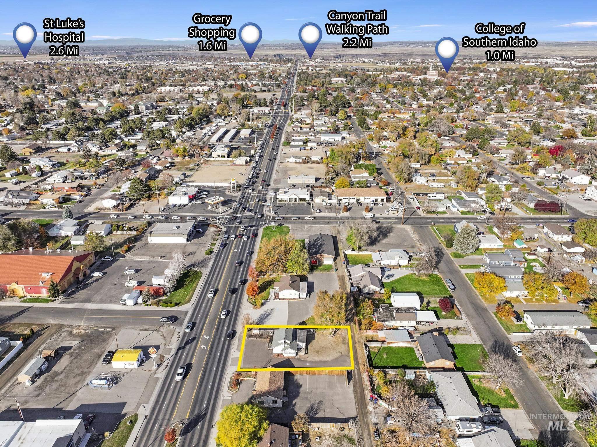 Aerial view of property and surrounding area featuring nearby suburban area and property boundaries highlighted