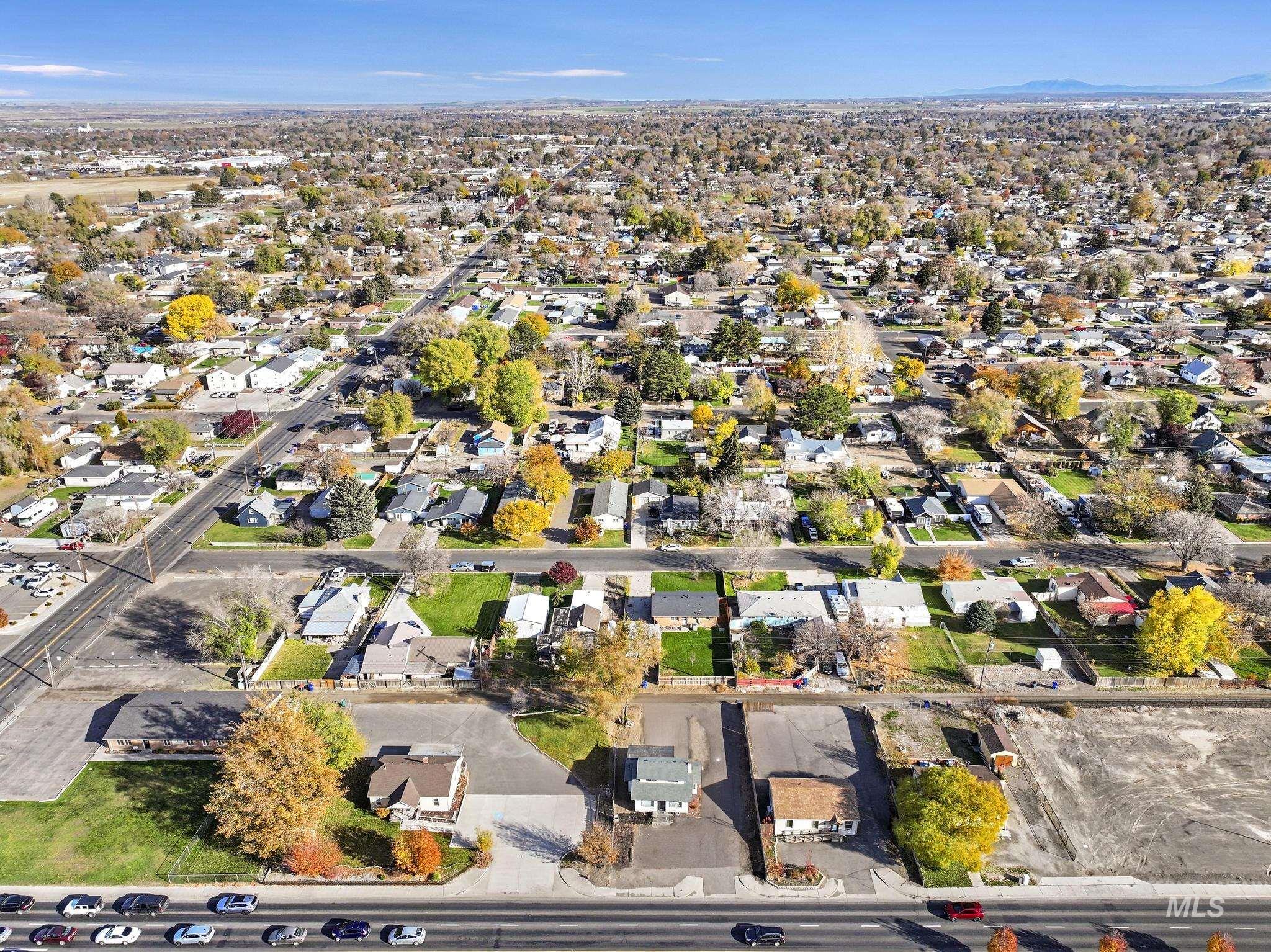 Aerial view of property and surrounding area featuring nearby suburban area