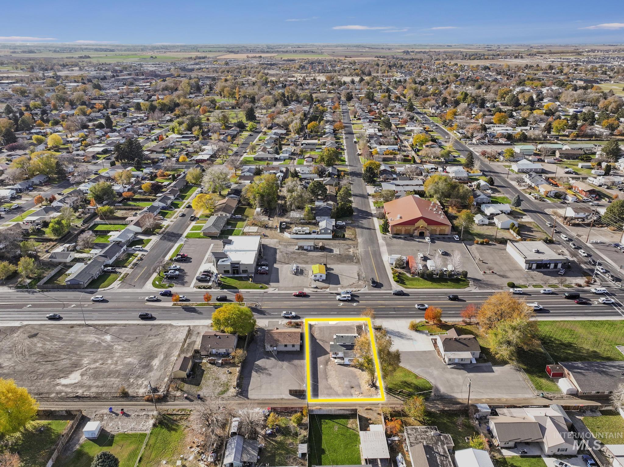 Aerial view of property and surrounding area with nearby suburban area