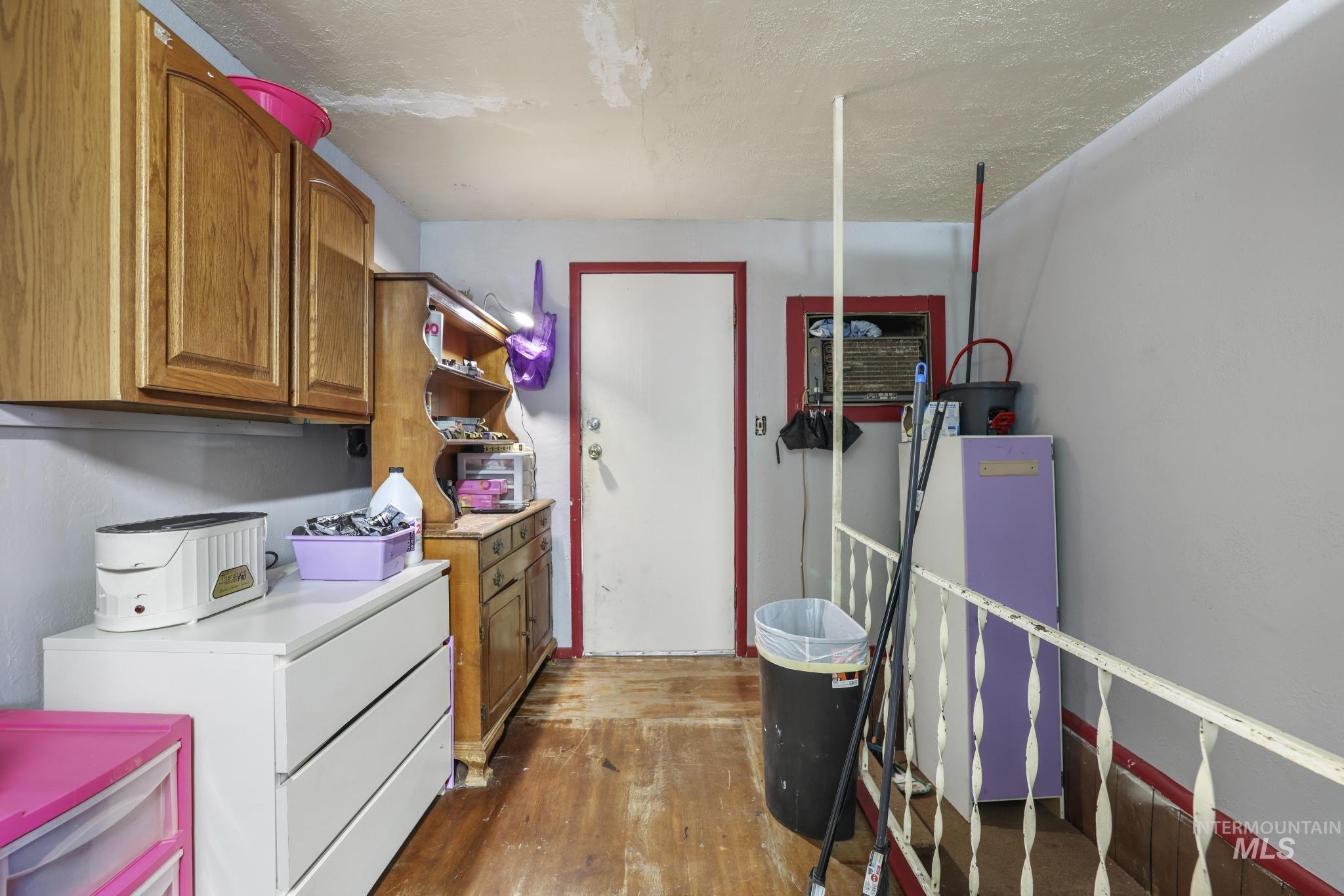 Laundry area with washer / dryer, dark wood-type flooring, and a textured ceiling
