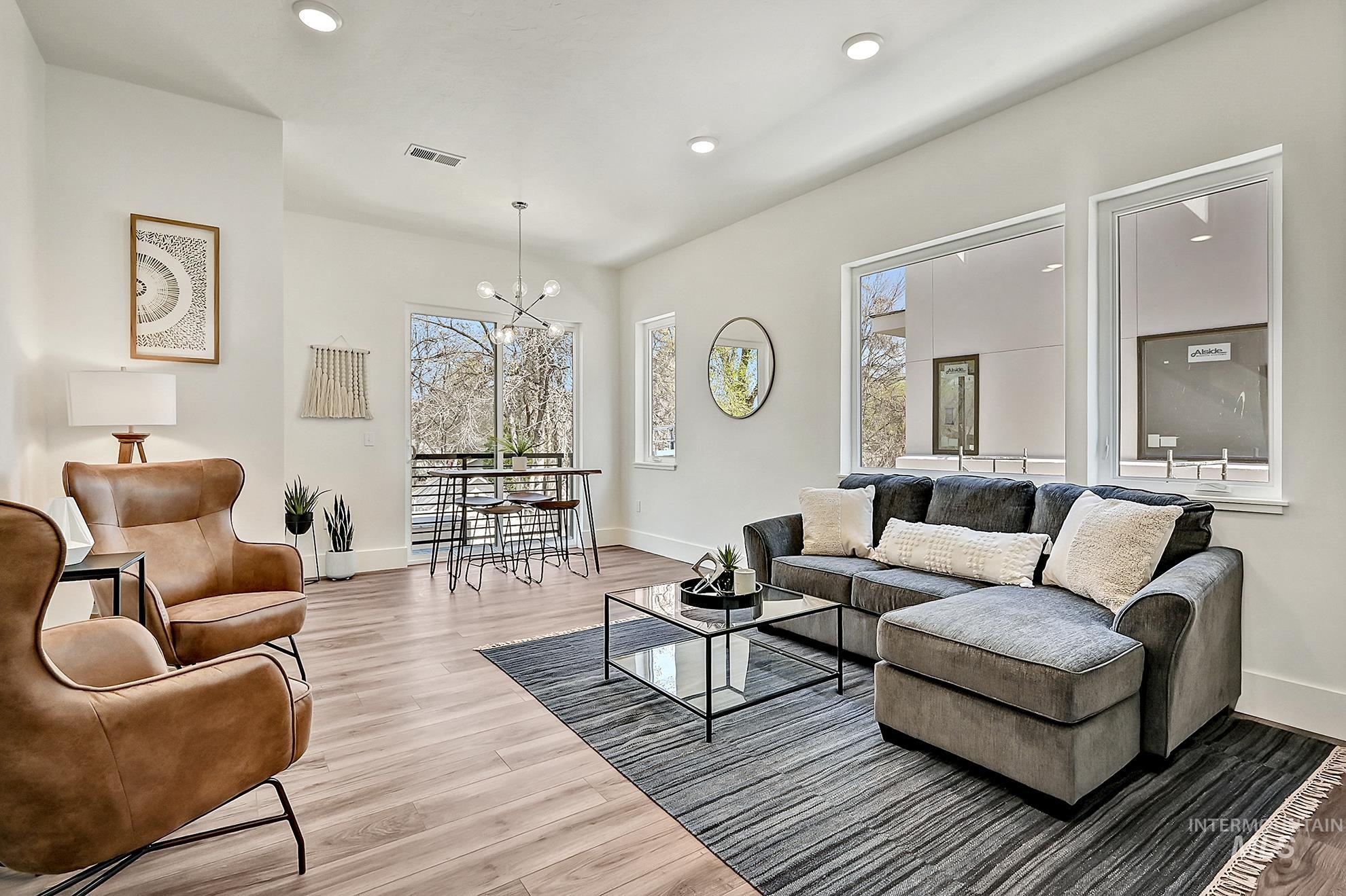 Living room with a chandelier, recessed lighting, and light wood-style floors