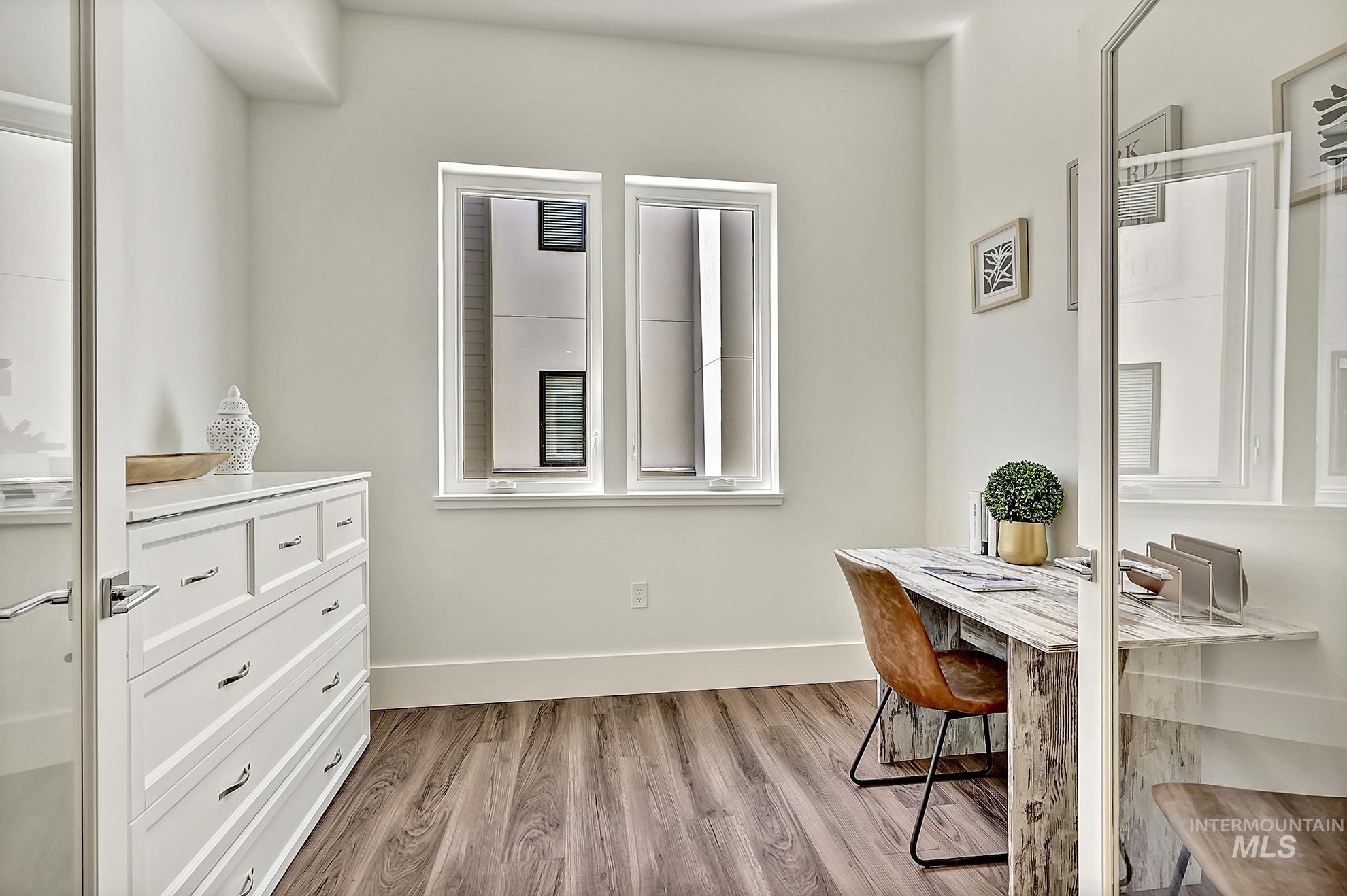 Home office featuring light wood-type flooring and baseboards