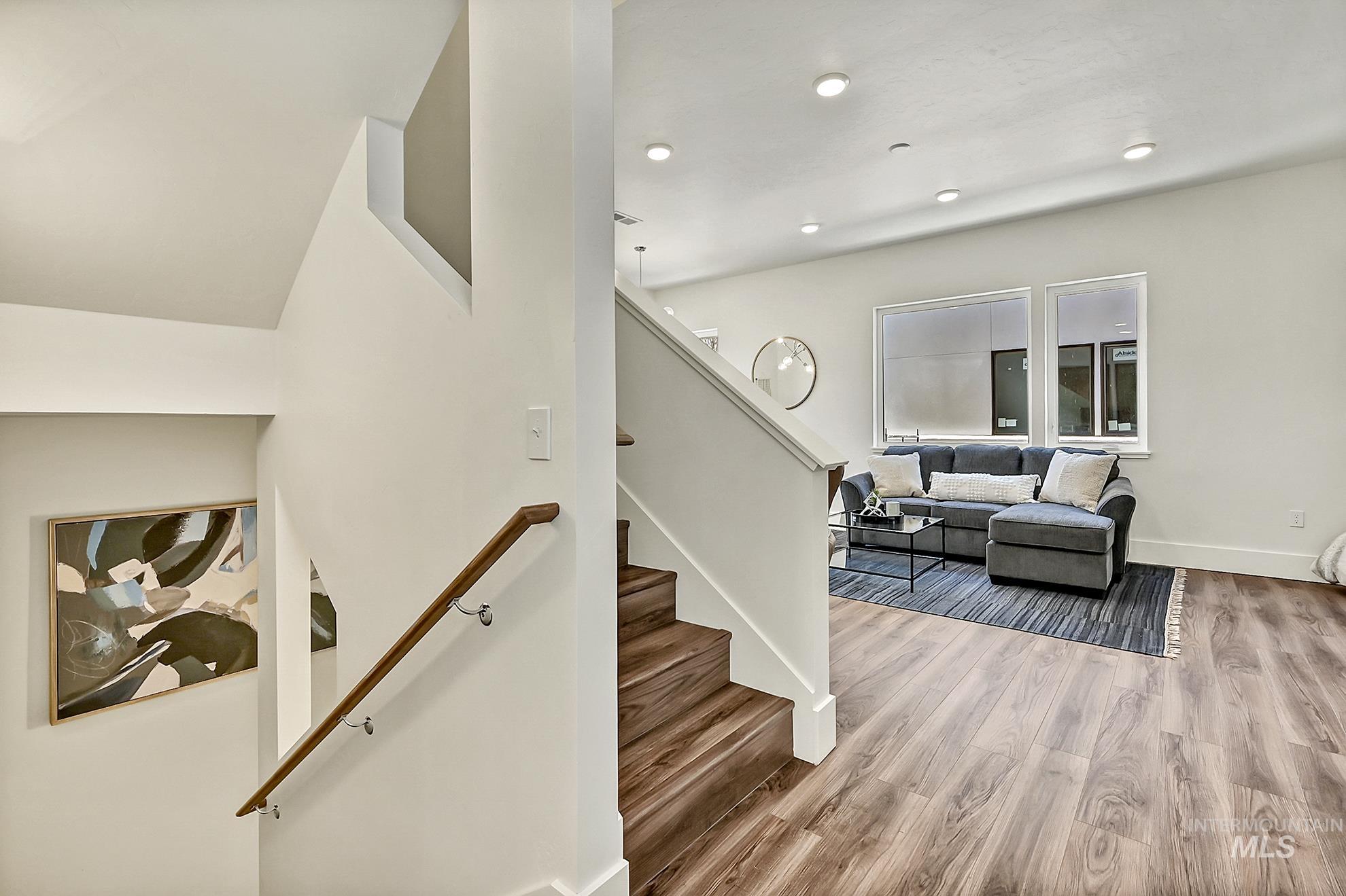 Stairway with wood finished floors and baseboards