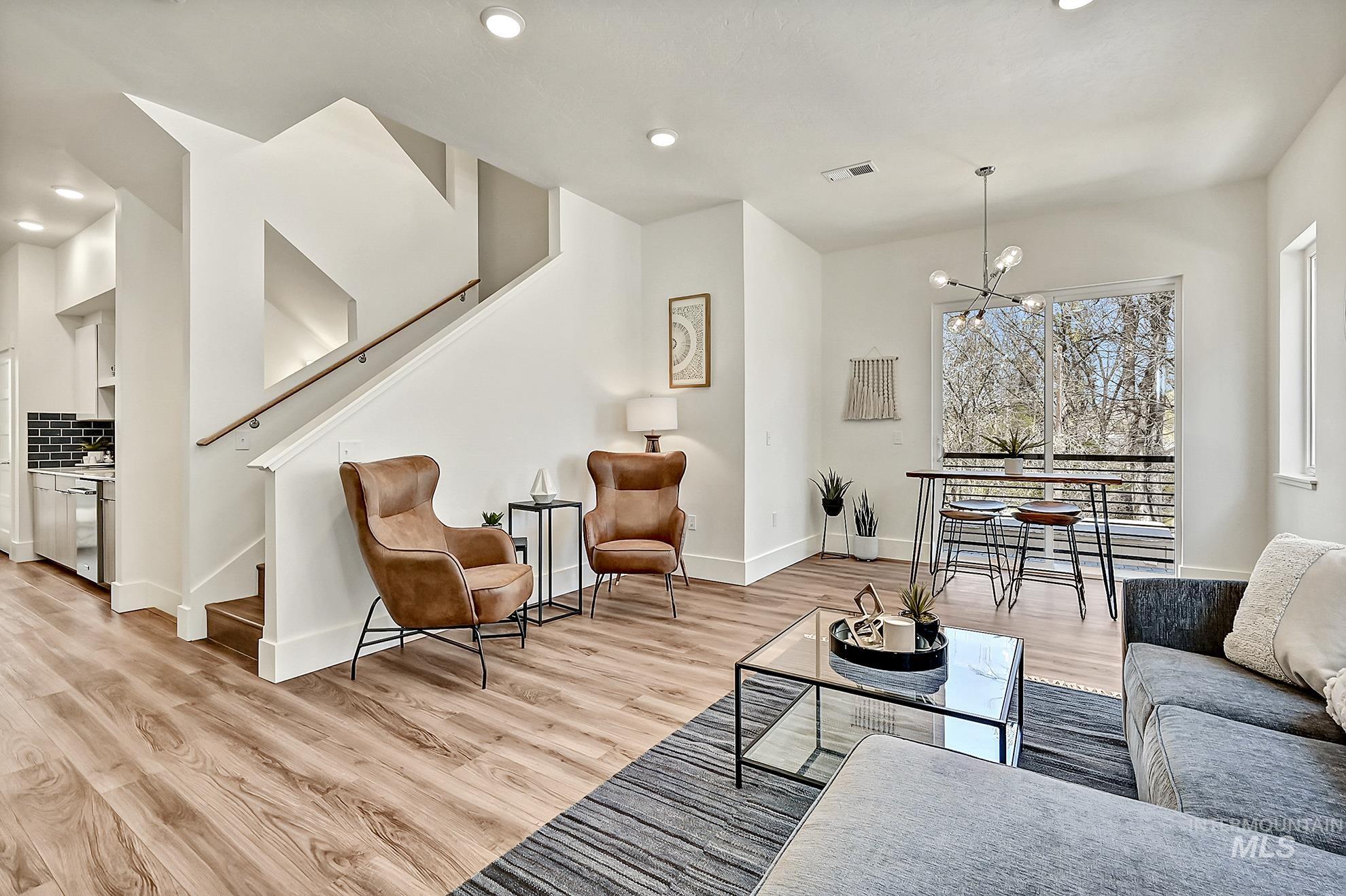 Living room featuring a chandelier, stairway, recessed lighting, and light wood-style floors