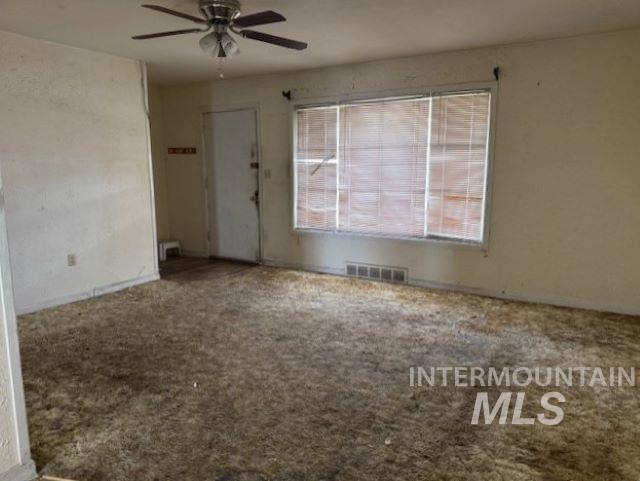 Carpeted spare room featuring ceiling fan