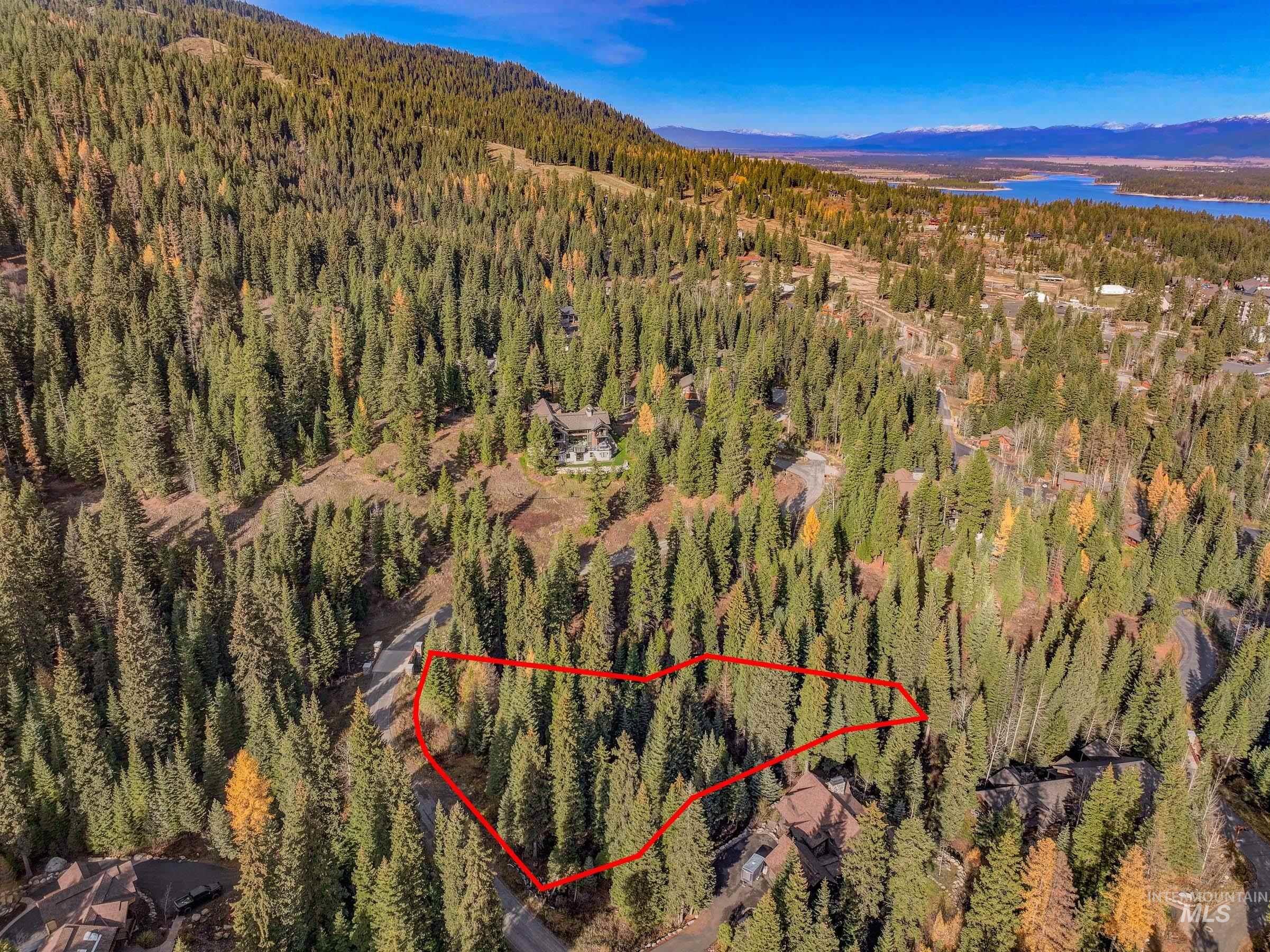 Aerial view of property and surrounding area with property parcel outlined and a large body of water