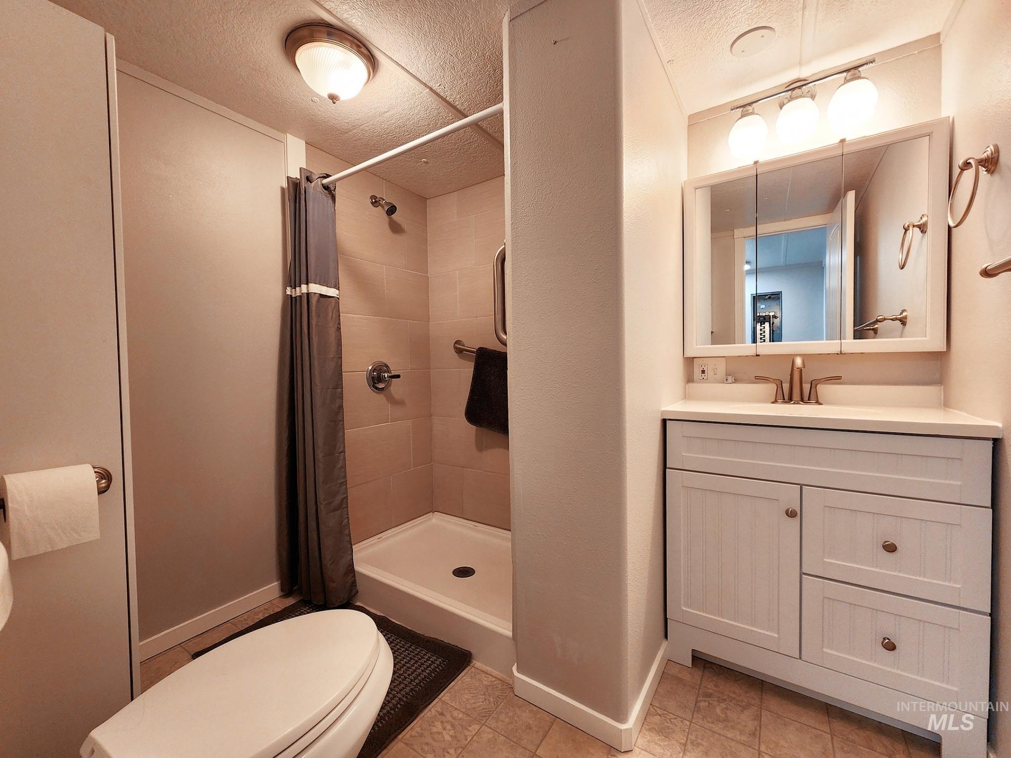 Updated bathroom with a clean walk-in shower, modern vanity, and warm lighting. Neutral finishes make it easy to personalize, offering a functional and move-in-ready space.