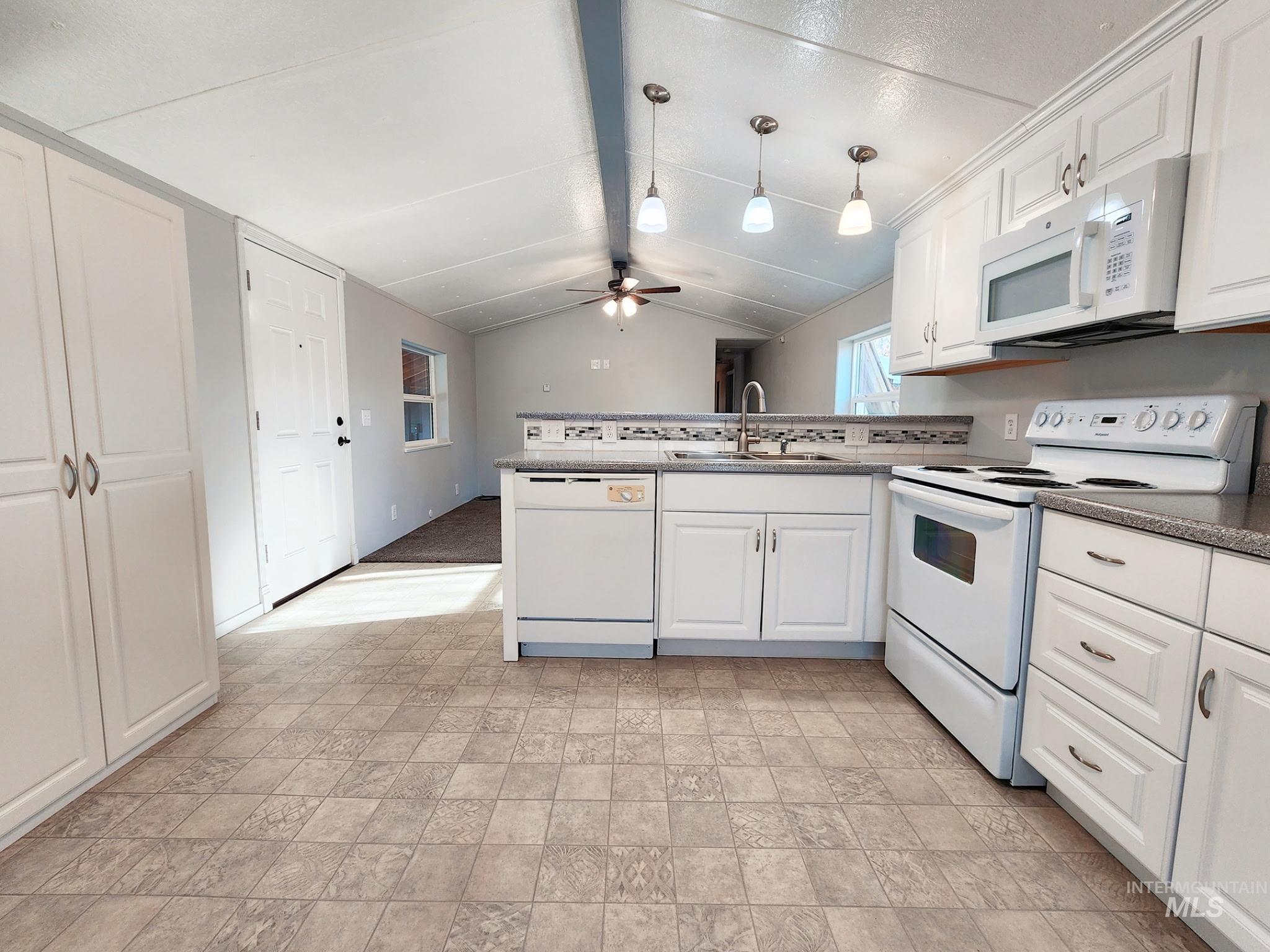 Light and bright kitchen with generous counter space, updated lighting, and clean white appliances. Open layout flows easily into the living area, creating a functional space for cooking, gathering, and everyday Idaho living.