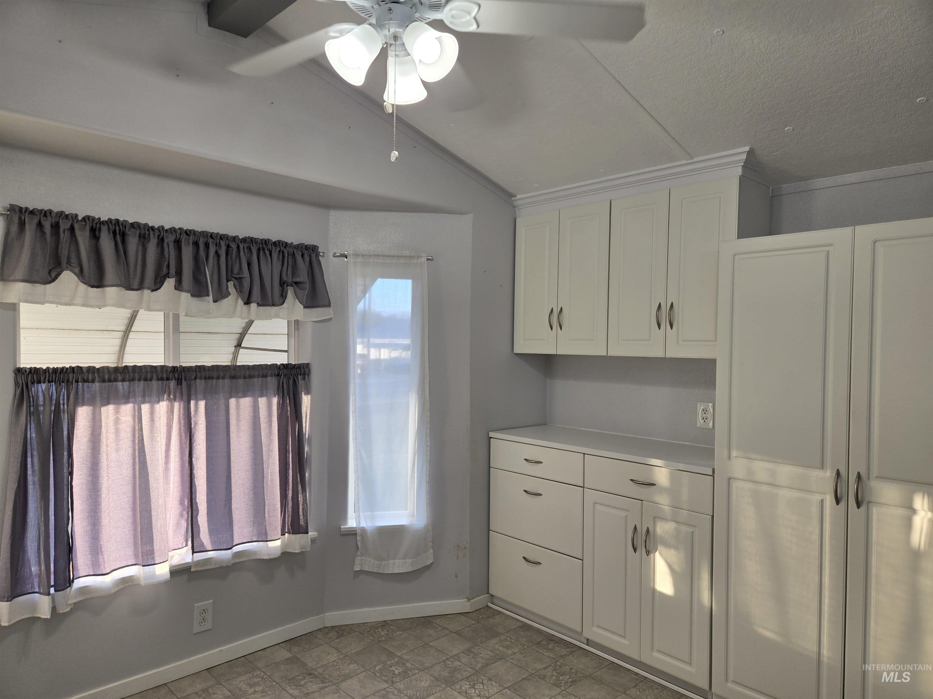 Bright dining nook with charming bay windows, built-in storage, and vaulted ceilings. Natural light fills the room, creating a warm, functional space ideal for meals, crafts, or a cozy reading spot.
