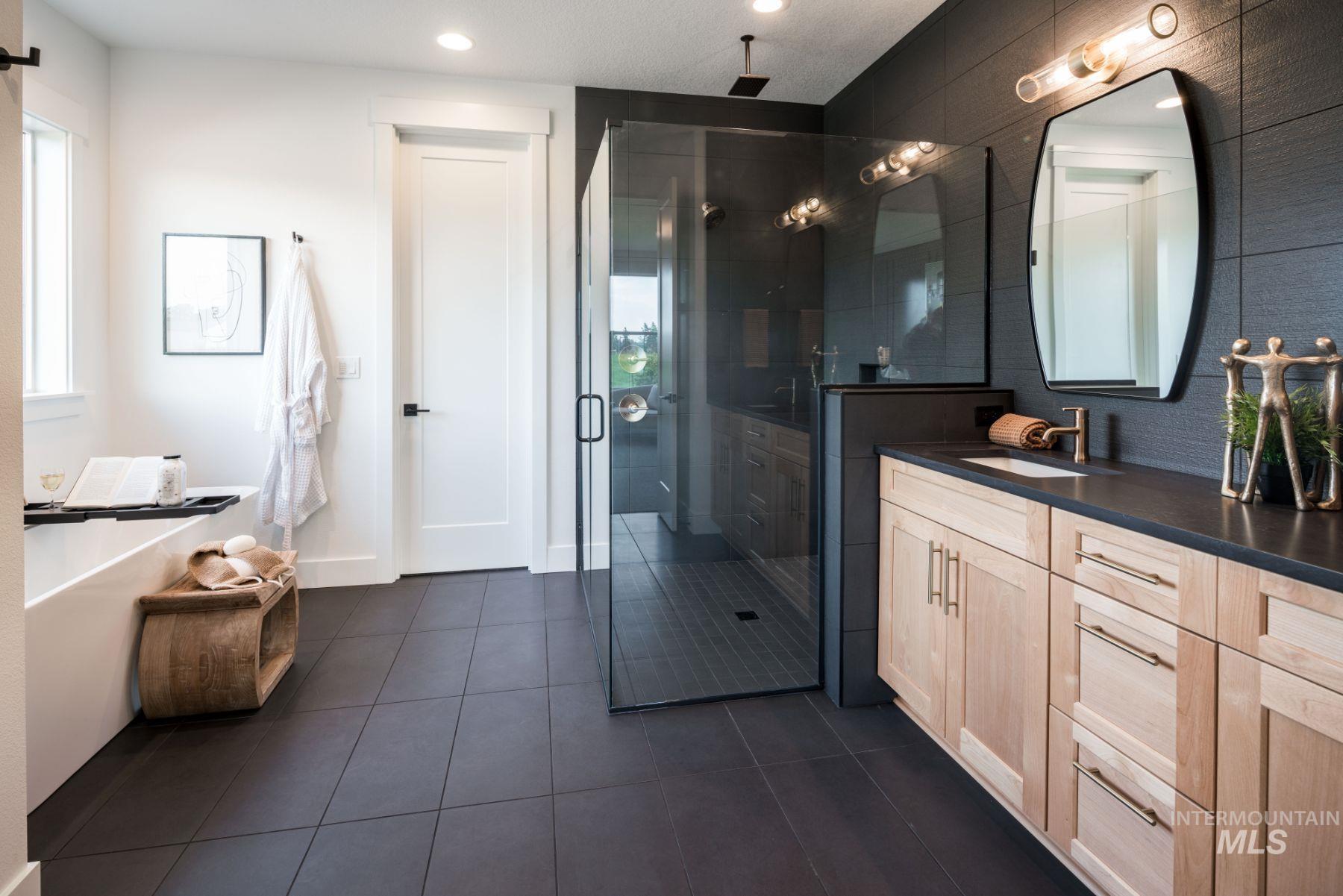 Bathroom with a stall shower, vanity, dark tile patterned floors, a soaking tub, and recessed lighting