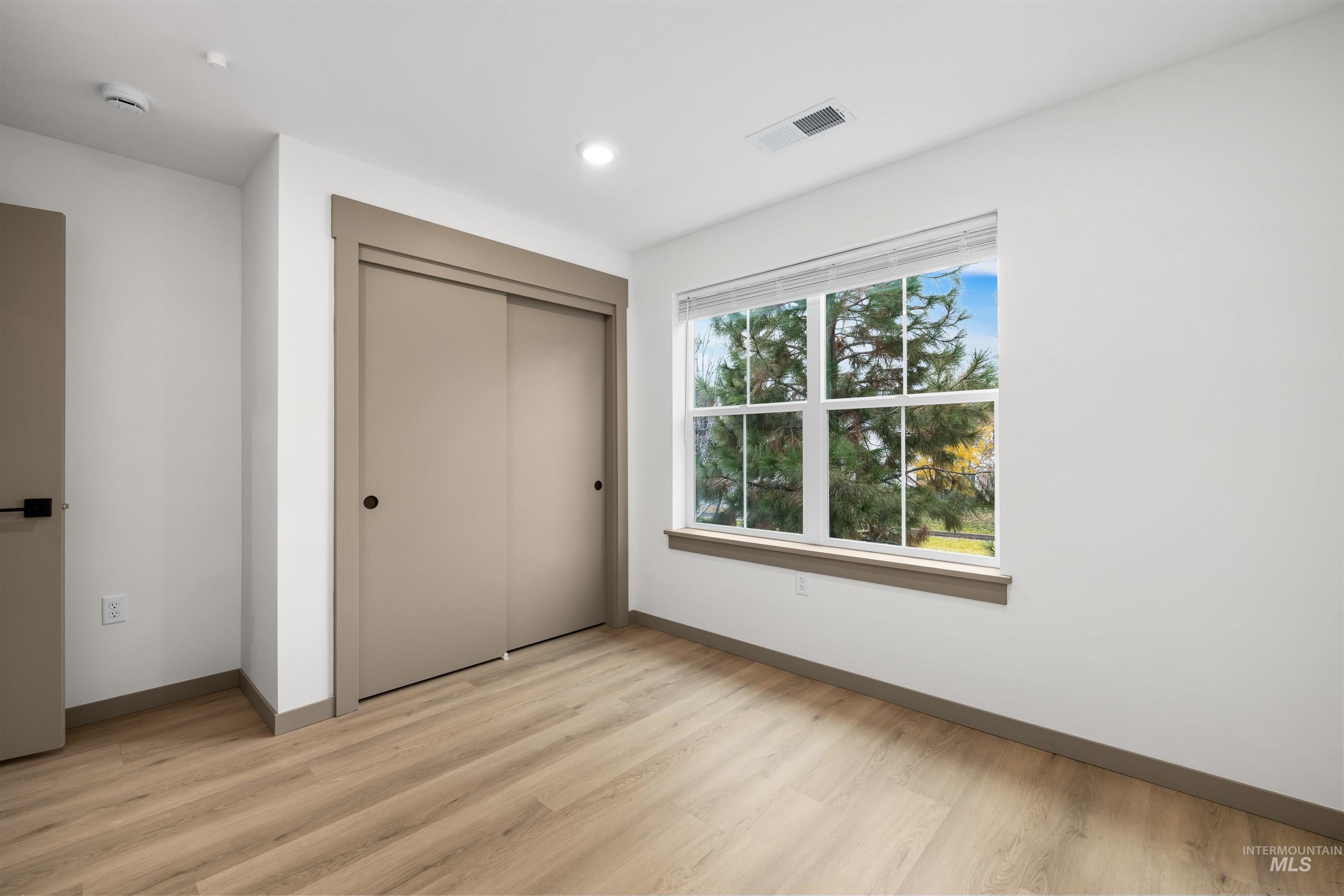 Unfurnished bedroom featuring a closet and light wood-style flooring