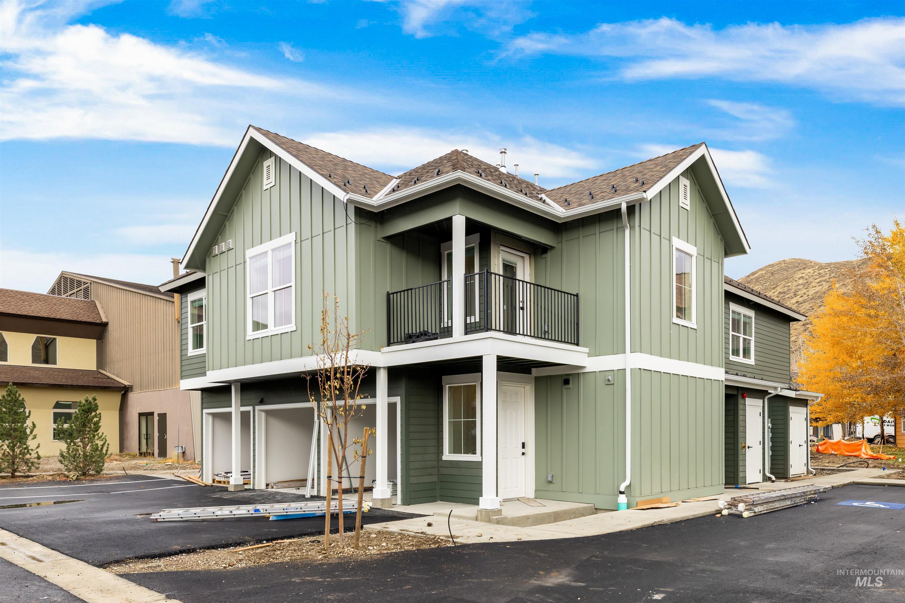 View of front of property with board and batten siding and a balcony