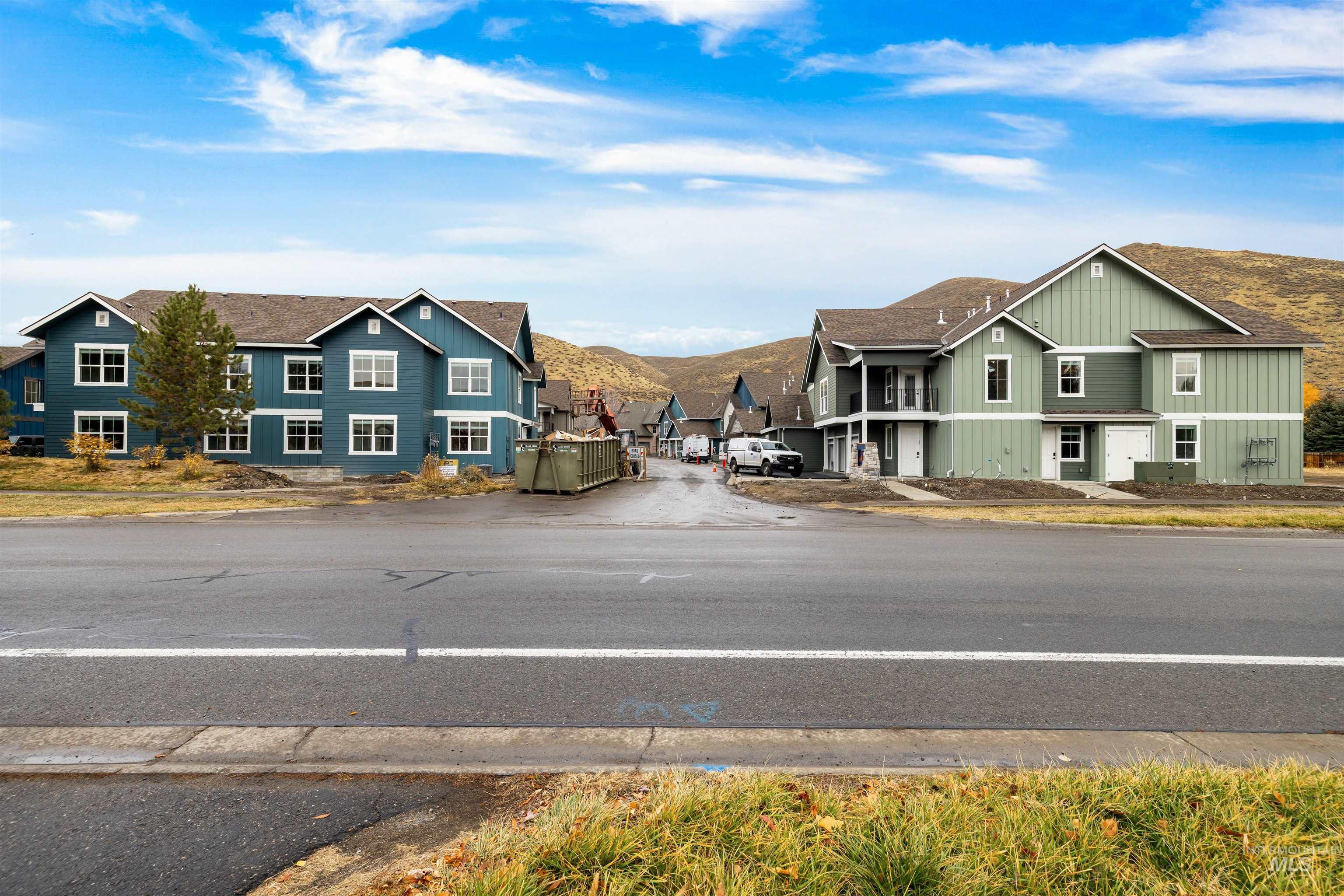 View of asphalt road featuring a residential view and curbs