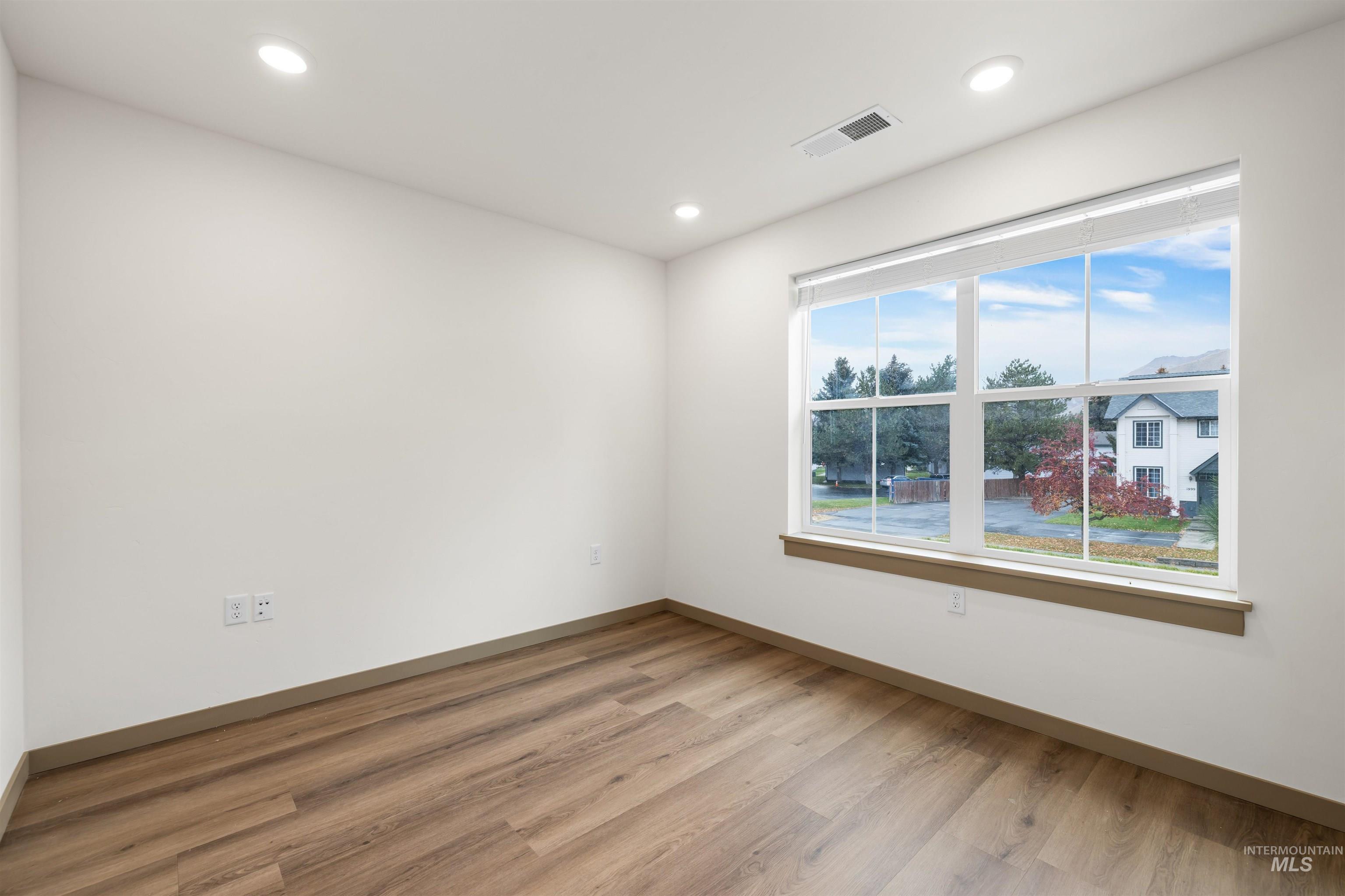 Empty room featuring light wood-style floors and recessed lighting