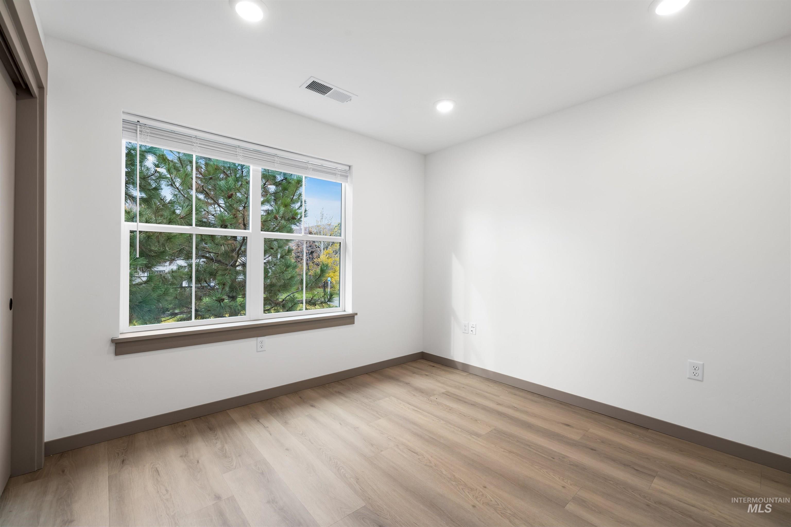 Spare room with light wood finished floors and recessed lighting