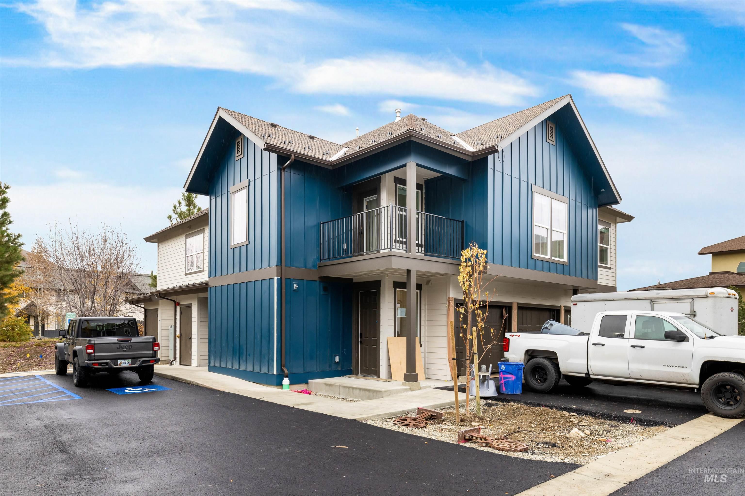 View of front of property with board and batten siding and a balcony