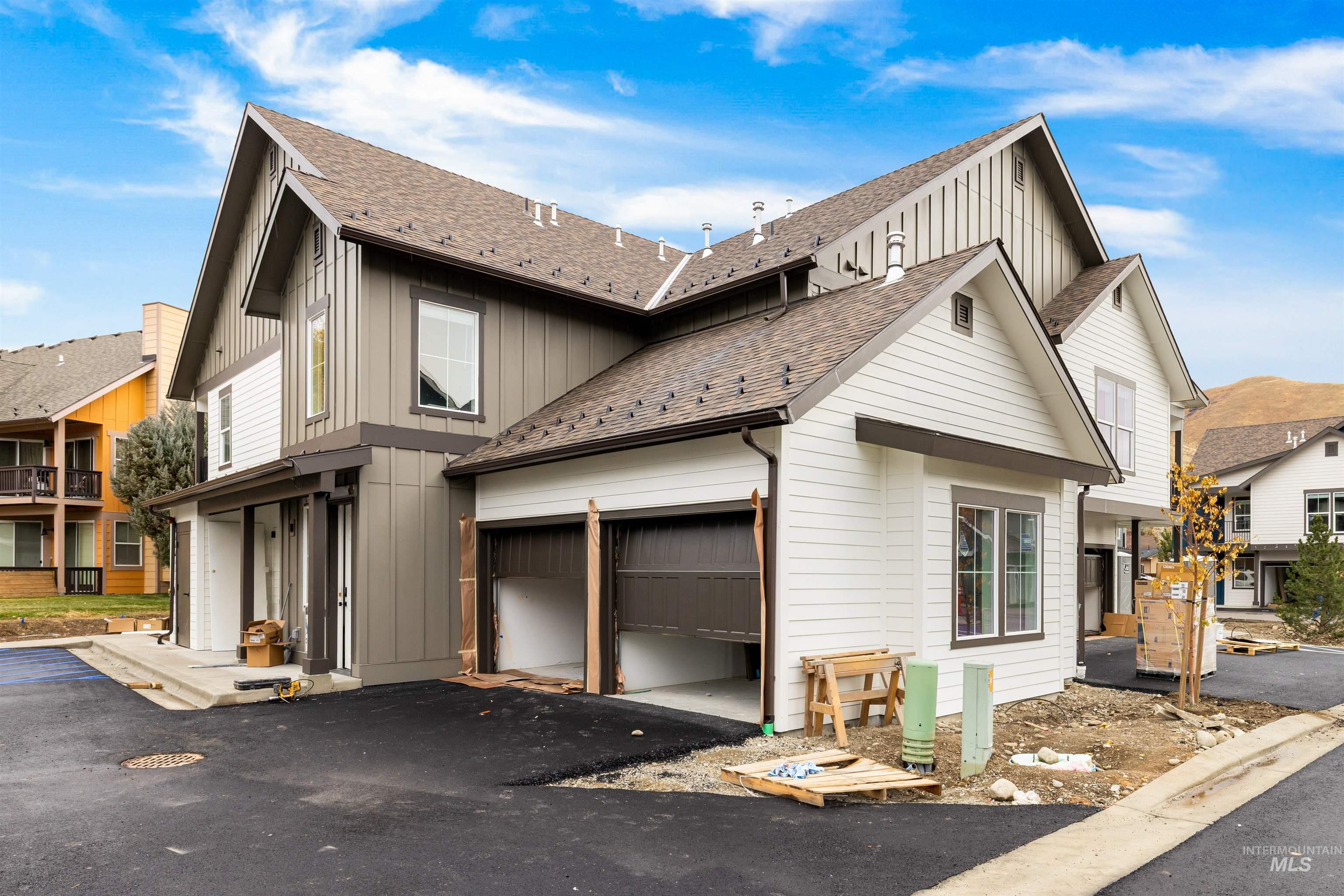 View of home's exterior featuring board and batten siding, a shingled roof, asphalt driveway, and an attached garage