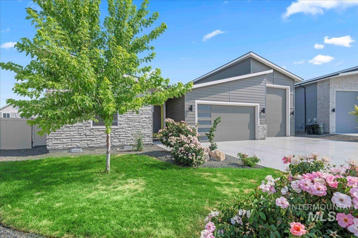 View of front of house featuring a garage, driveway, and stone siding
