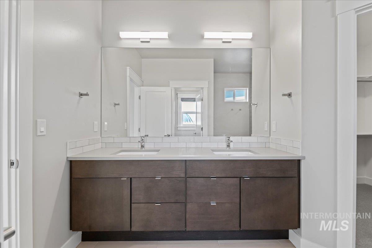 Full bath with double vanity and a walk in closet