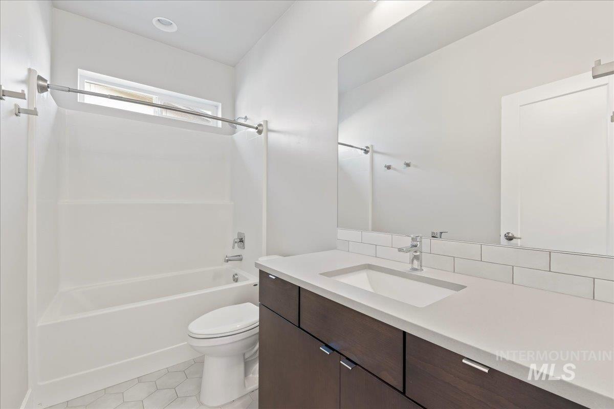 Bathroom with vanity, bathing tub / shower combination, and tile patterned floors