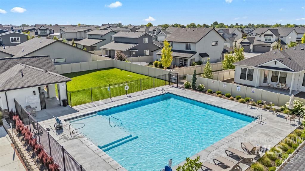 Community pool featuring a residential view, a fenced backyard, and a patio area
