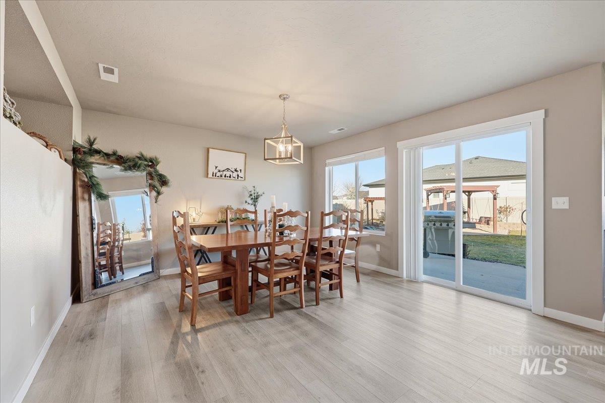 Dining room with light wood finished floors and plenty of natural light