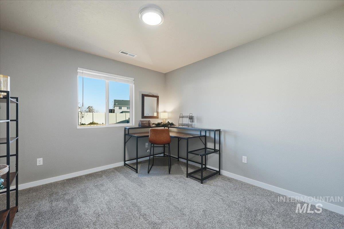 Home office featuring light colored carpet and baseboards