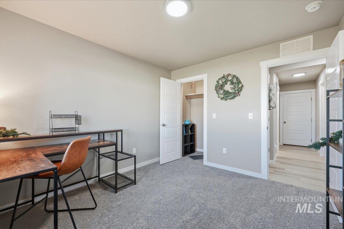 Office area featuring light carpet and baseboards