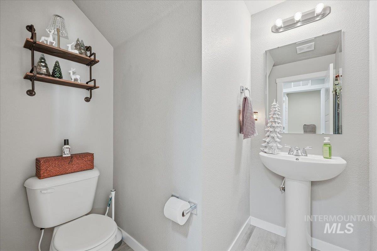 Half bathroom with toilet and a textured wall