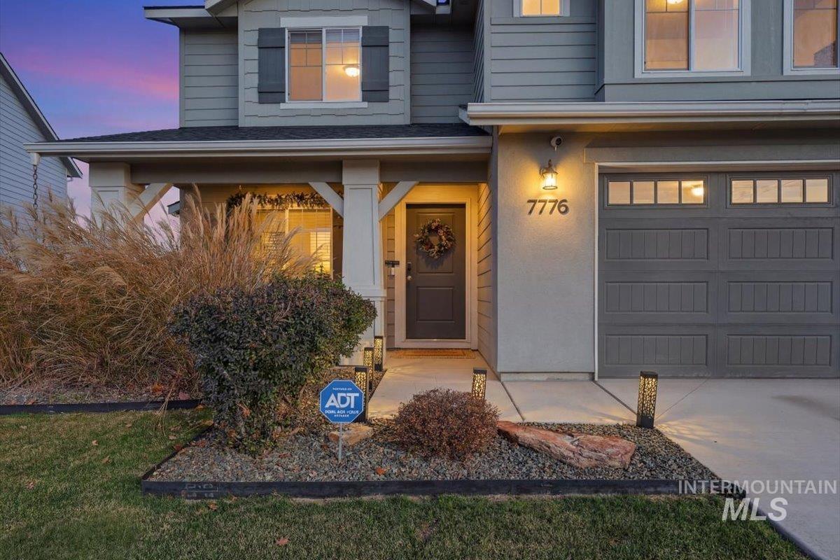 Exterior entry at dusk with a porch and a garage